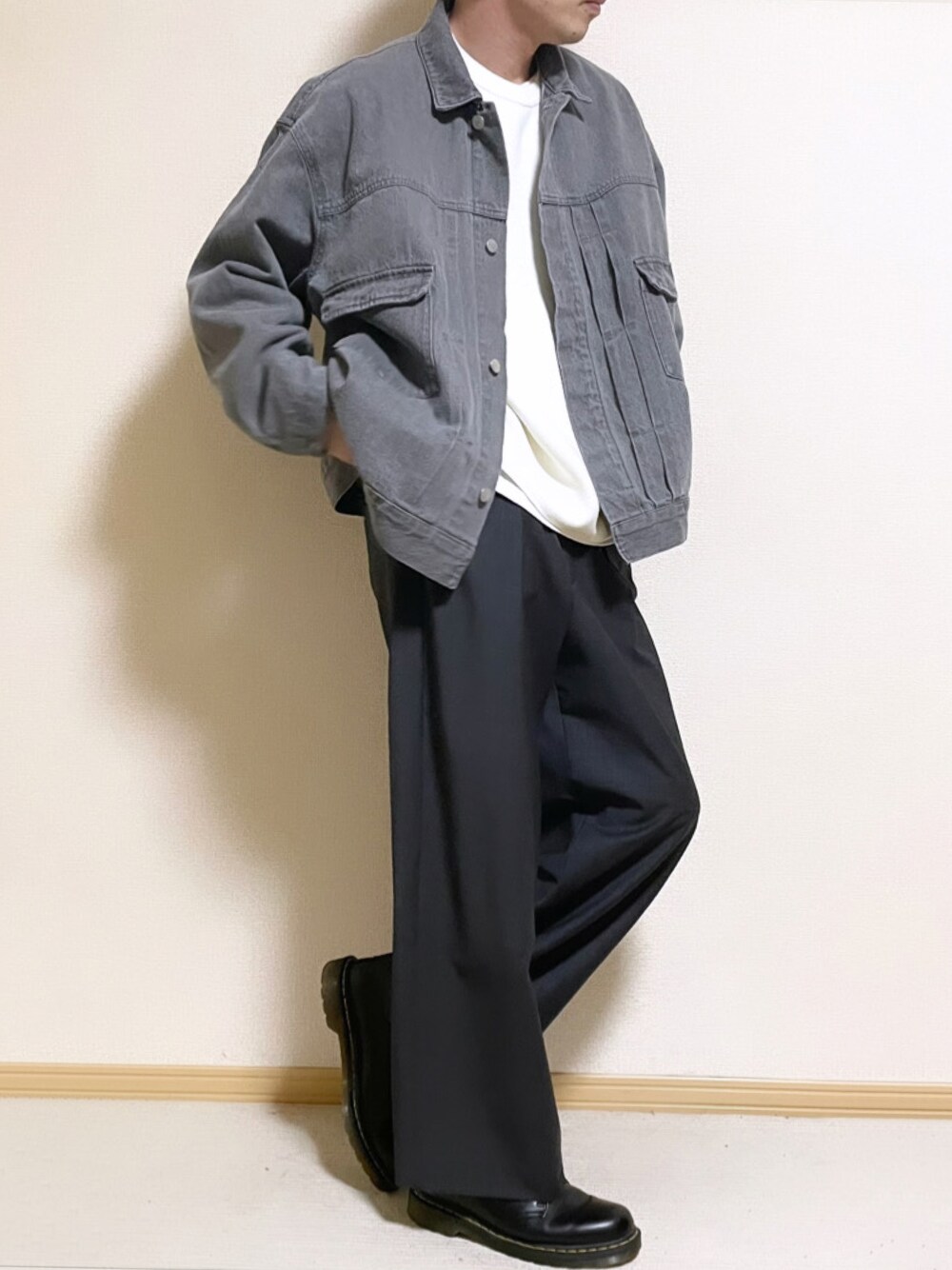 グレー系のセットアップ、ホワイト系のニット/セーター、ホワイト系のタンクトップを着用したメンズの冬コーディネートの1枚目の写真