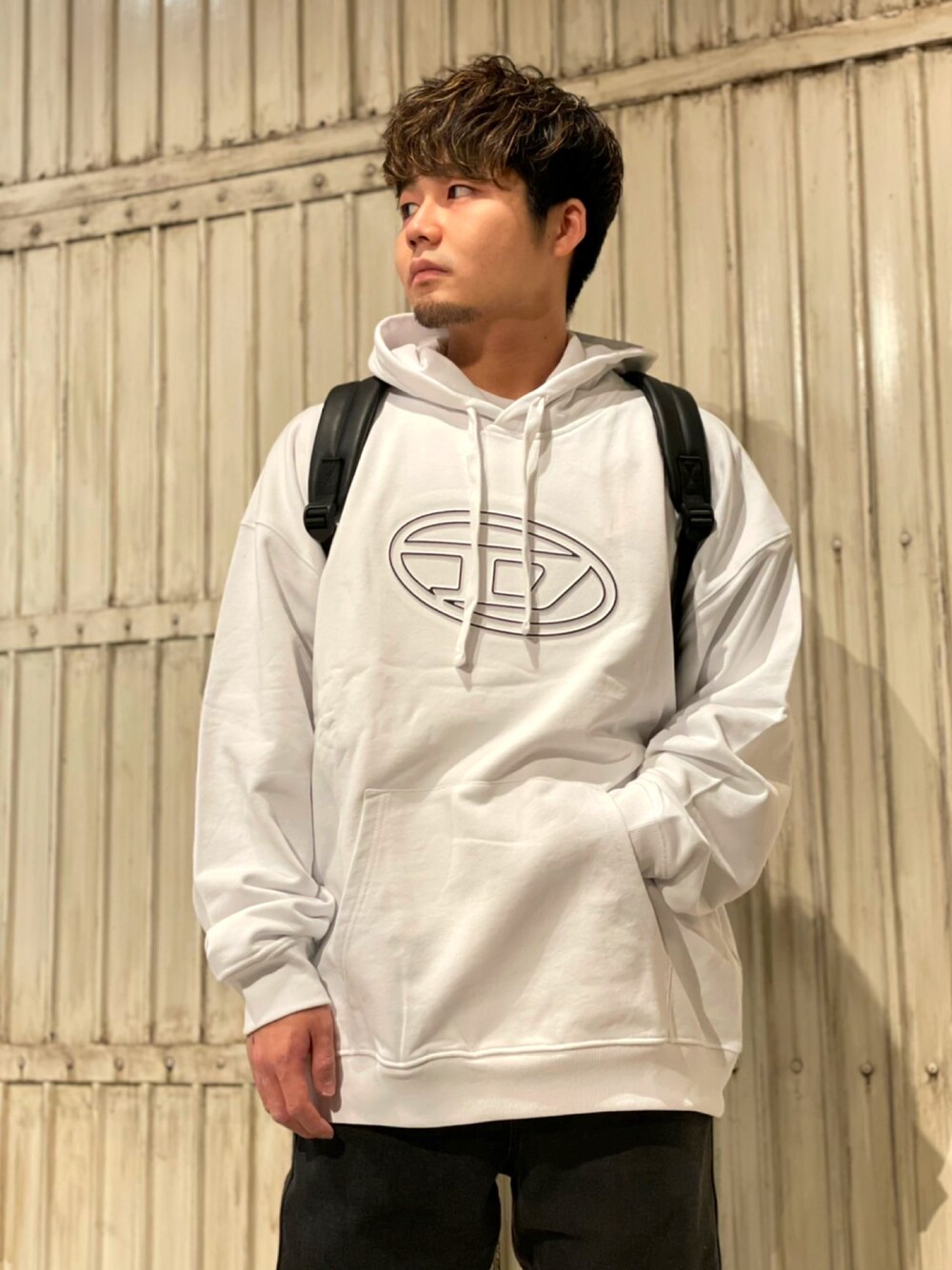 「Diesel、dieselshibuya、しぶやすたっふ、私の推しブランド、パーカー、フーディー、ロゴ、ロゴスウェット、ロゴパーカー、ロゴトレーナー、デニム、ジョグジーンズ、トラックデニム、リュック、フェイクレザー」｜「DIESELのユニセックス スウェット パーカー リラックスフィット（パーカー、ホワイト系）」を使った、けんてぃーさん（メンズ・169cm）の冬コーディネートの1枚目の写真