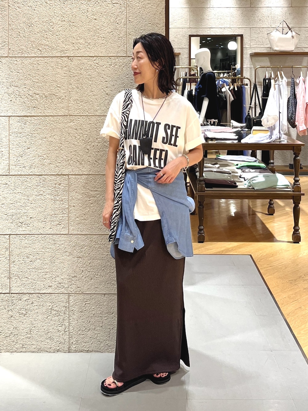 ブラック系のサンダル、ブルー系のシャツ/ブラウス、ブラウン系のワンピースを着用したレディースの夏コーディネートの1枚目の写真