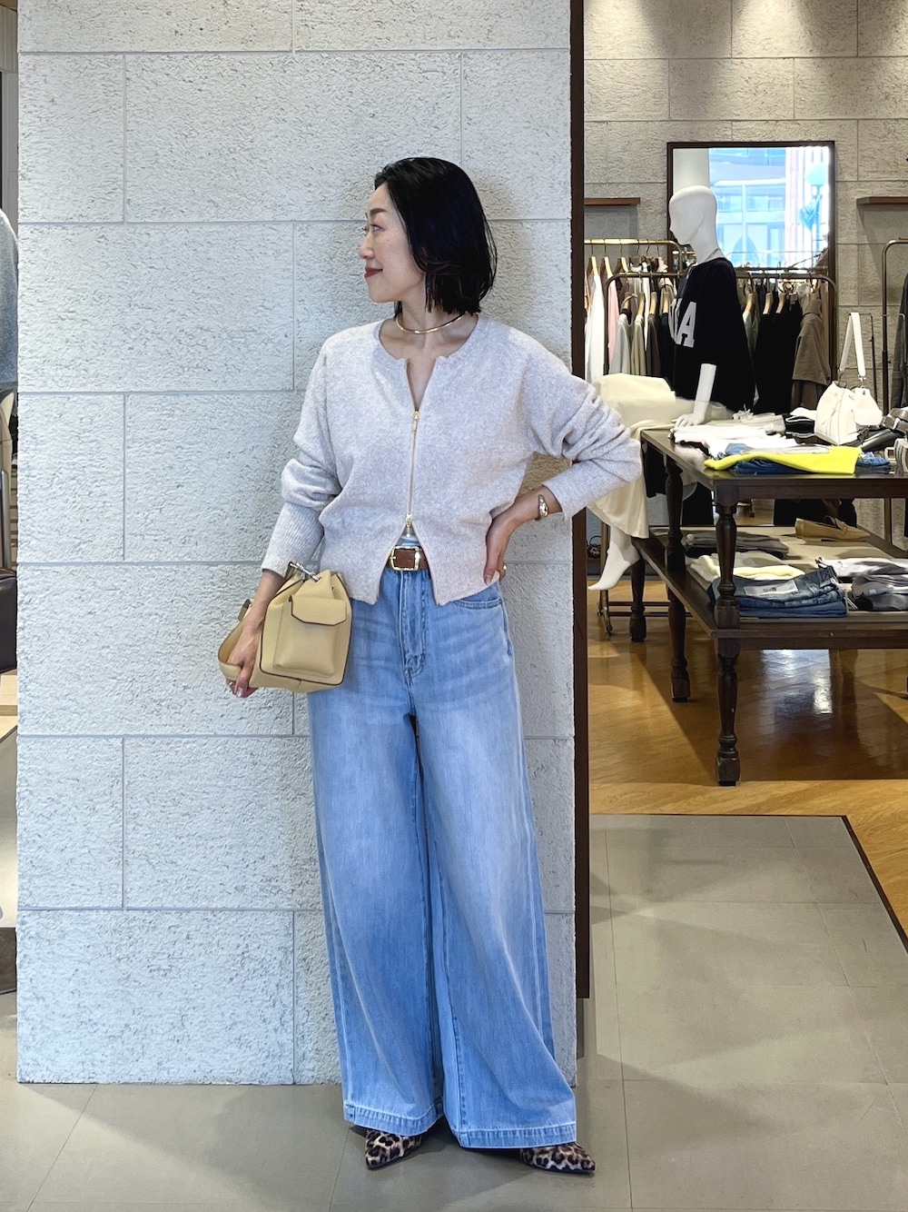 ベージュ系のその他シューズ、ベージュ系のショルダーバッグ、ブルー系のデニムパンツを着用したレディースの春コーディネートの1枚目の写真