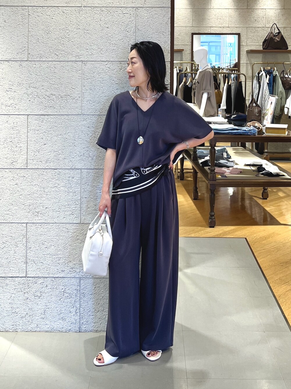 グレー系のTシャツ/カットソー、ホワイト系のその他シューズ、ホワイト系のボストンバッグを着用したレディースの春コーディネートの1枚目の写真