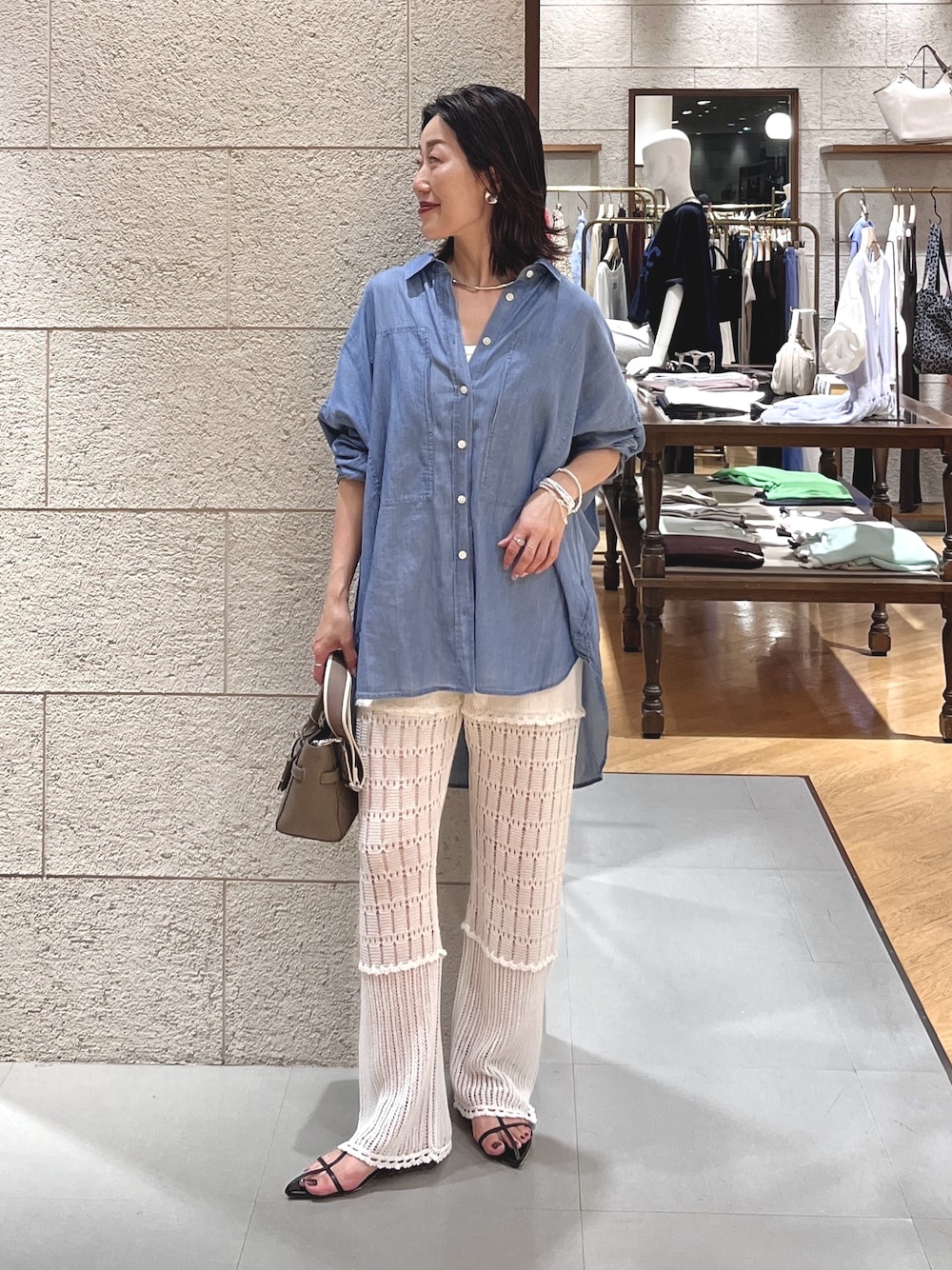 グレー系のトートバッグ、ホワイト系のその他パンツ、ブルー系のシャツ/ブラウスを着用したレディースの夏コーディネートの1枚目の写真
