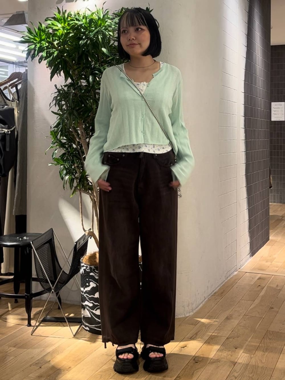 グリーン系のカーディガン/ボレロ、ブラウン系のデニムパンツ、ブラック系のサンダルを着用したレディースの夏コーディネートの1枚目の写真