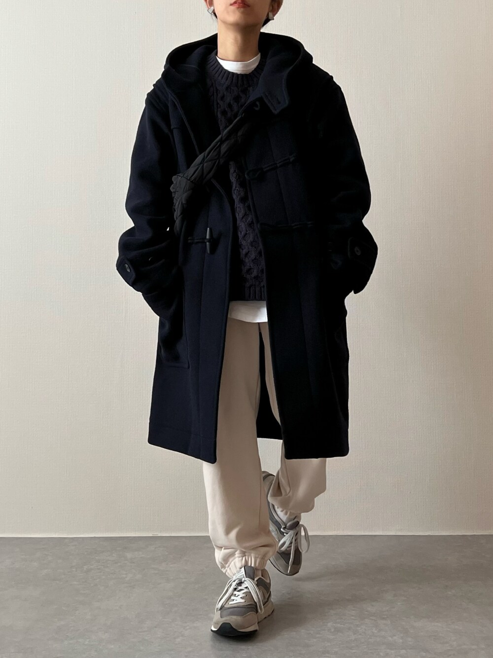 ブルー系のダッフルコート、ブルー系のニット/セーター、ホワイト系のスウェットパンツを着用したレディースの冬コーディネートの1枚目の写真