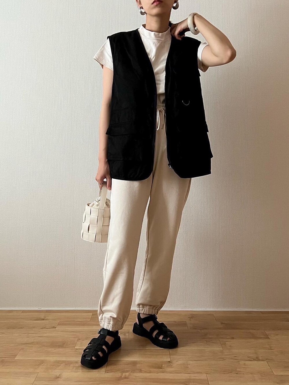 ホワイト系のスウェットパンツ、ホワイト系のTシャツ/カットソー、ブラック系のベストを着用したレディースの夏コーディネートの1枚目の写真