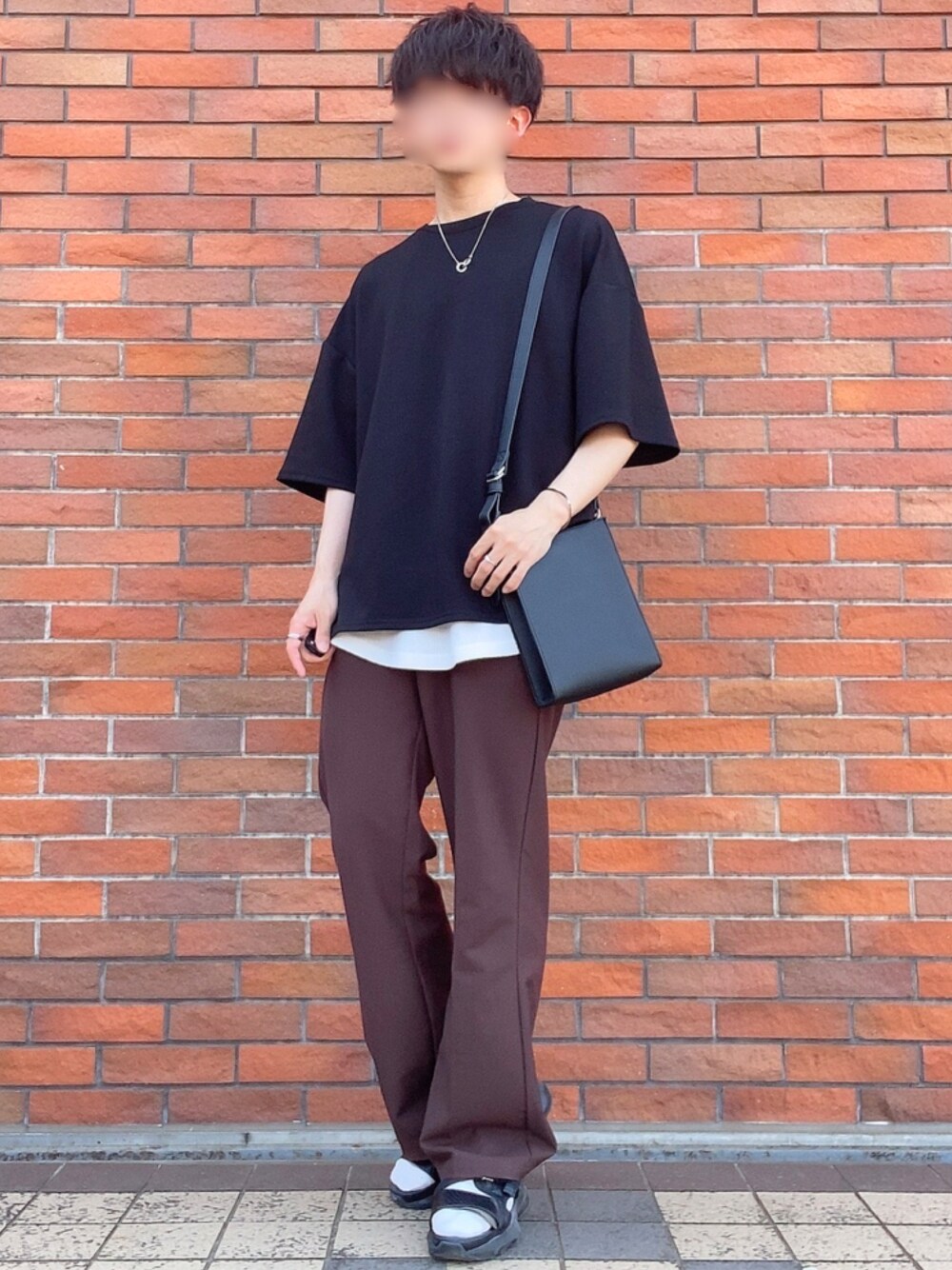 ブラウン系のスラックス、ブラック系のサンダル、ブラック系のTシャツ/カットソーを着用したメンズの春コーディネートの1枚目の写真