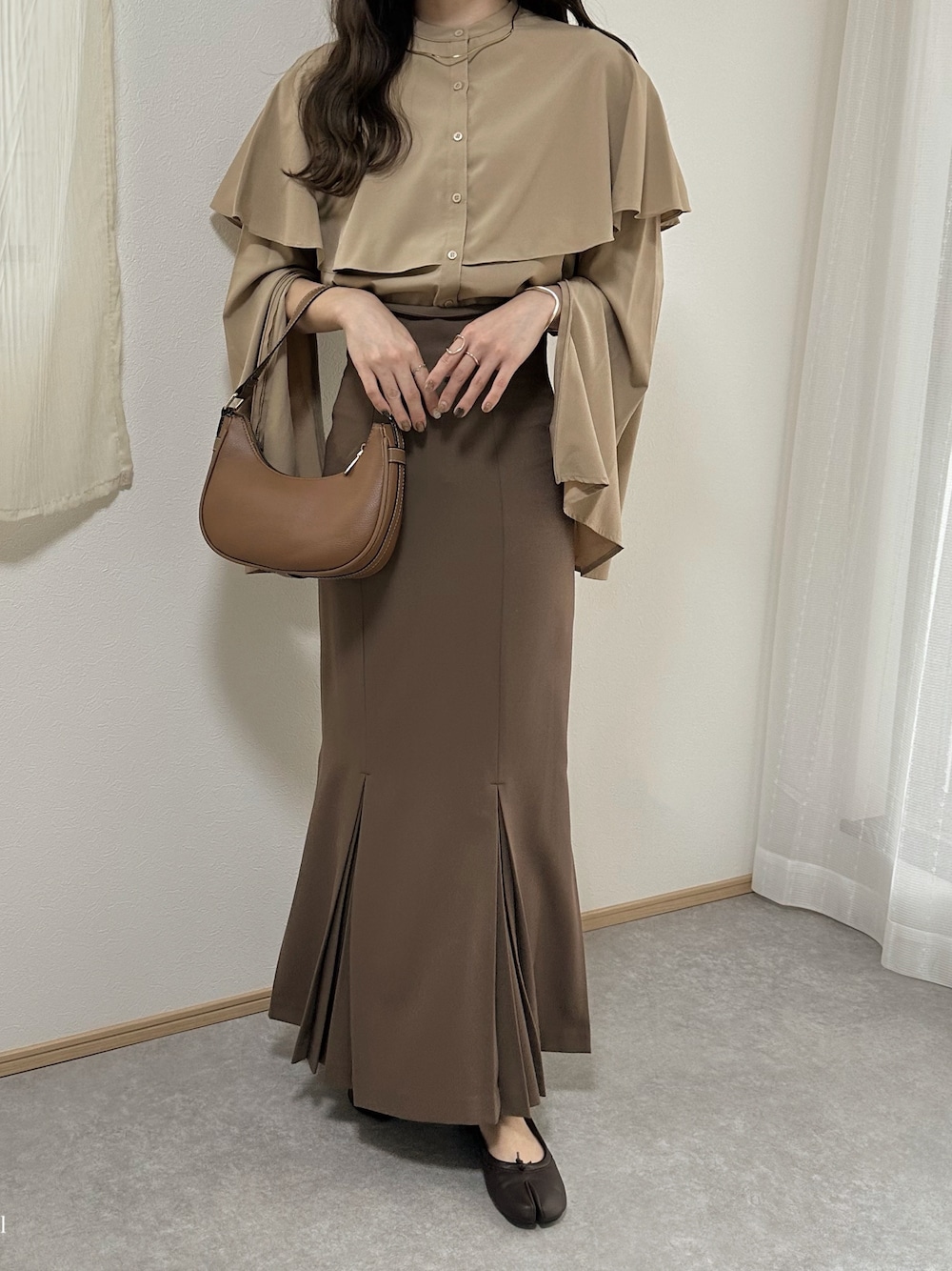 ベージュ系のシャツ/ブラウス、ブラウン系のハンドバッグ、ブラウン系のスカートを着用したレディースの秋コーディネートの1枚目の写真