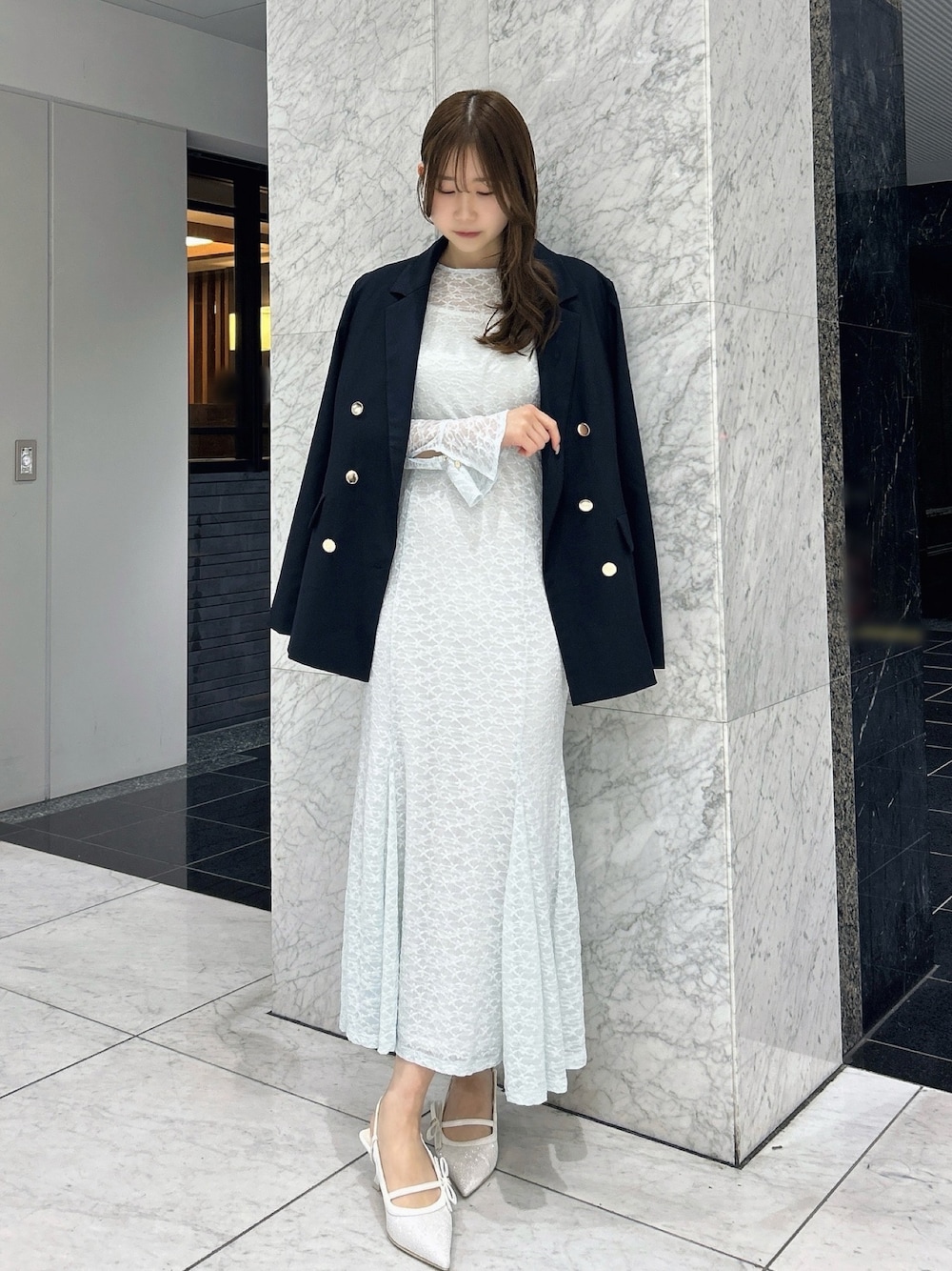 ブルー系のテーラードジャケット、ブルー系のワンピース、ホワイト系のパンプスを着用したレディースの春コーディネートの1枚目の写真