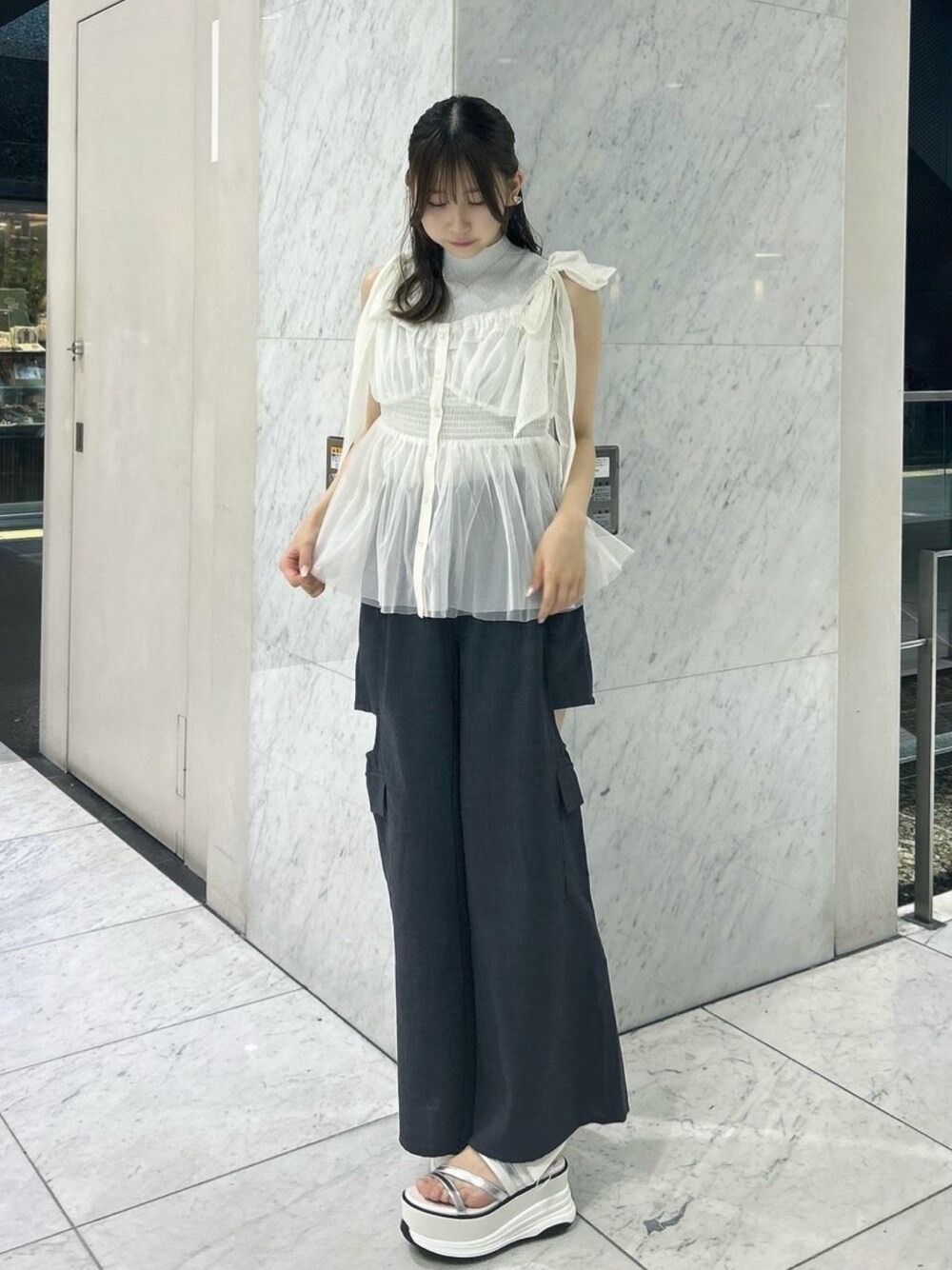 グレー系のニット/セーター、ホワイト系のタンクトップ、ホワイト系のサンダルを着用したレディースの夏コーディネートの1枚目の写真