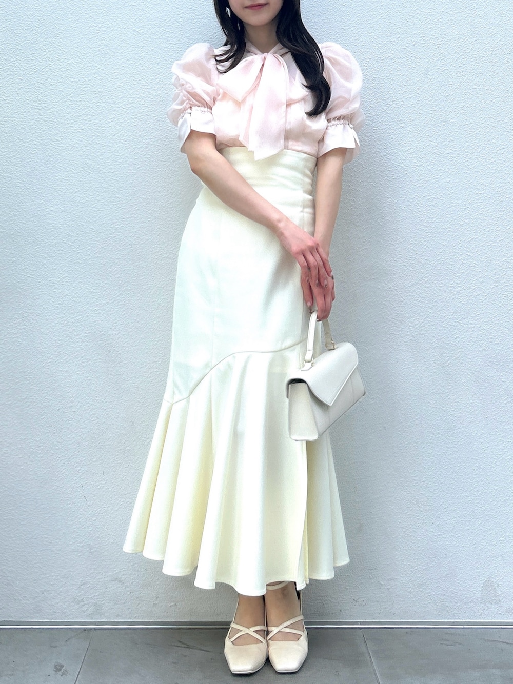 ピンク系のシャツ/ブラウス、ホワイト系のスカート、ホワイト系のサンダルを着用したレディースの春コーディネートの1枚目の写真