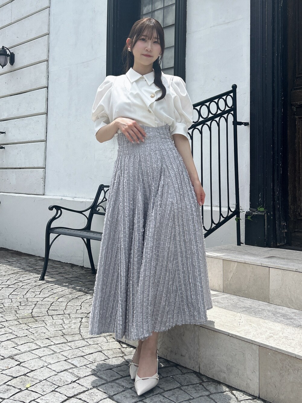 グレー系のスカート、ホワイト系のシャツ/ブラウスを着用したレディースの夏コーディネートの1枚目の写真