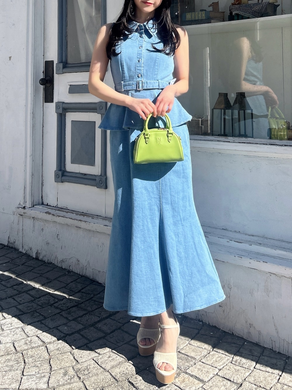 ブルー系のワンピース、ホワイト系のサンダル、イエロー系のハンドバッグを着用したレディースの春コーディネートの1枚目の写真