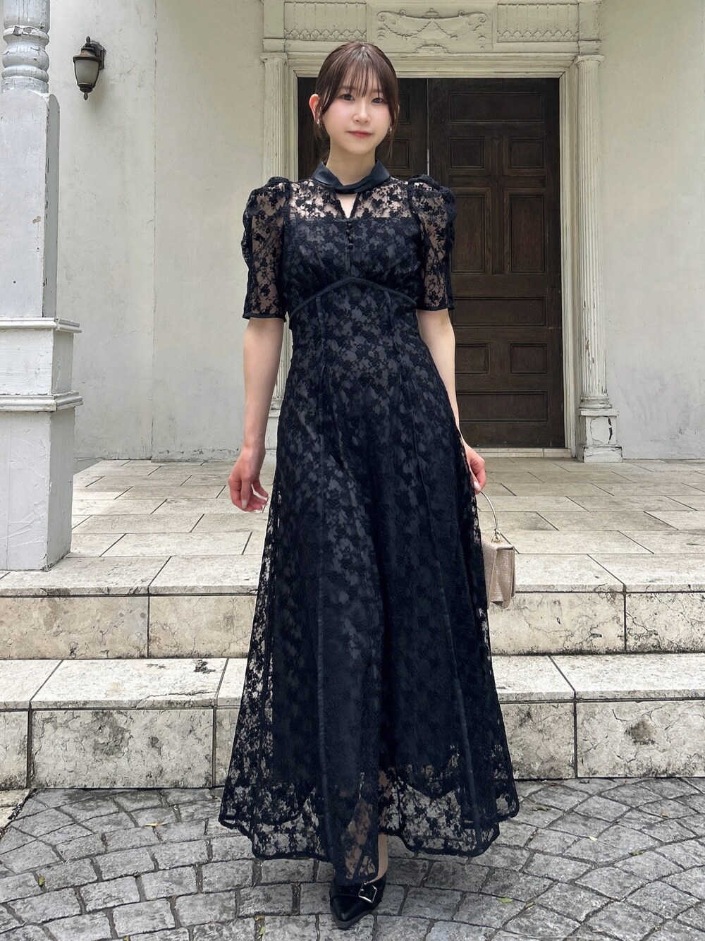 ブラック系のドレスを着用したレディースの夏コーディネートの1枚目の写真