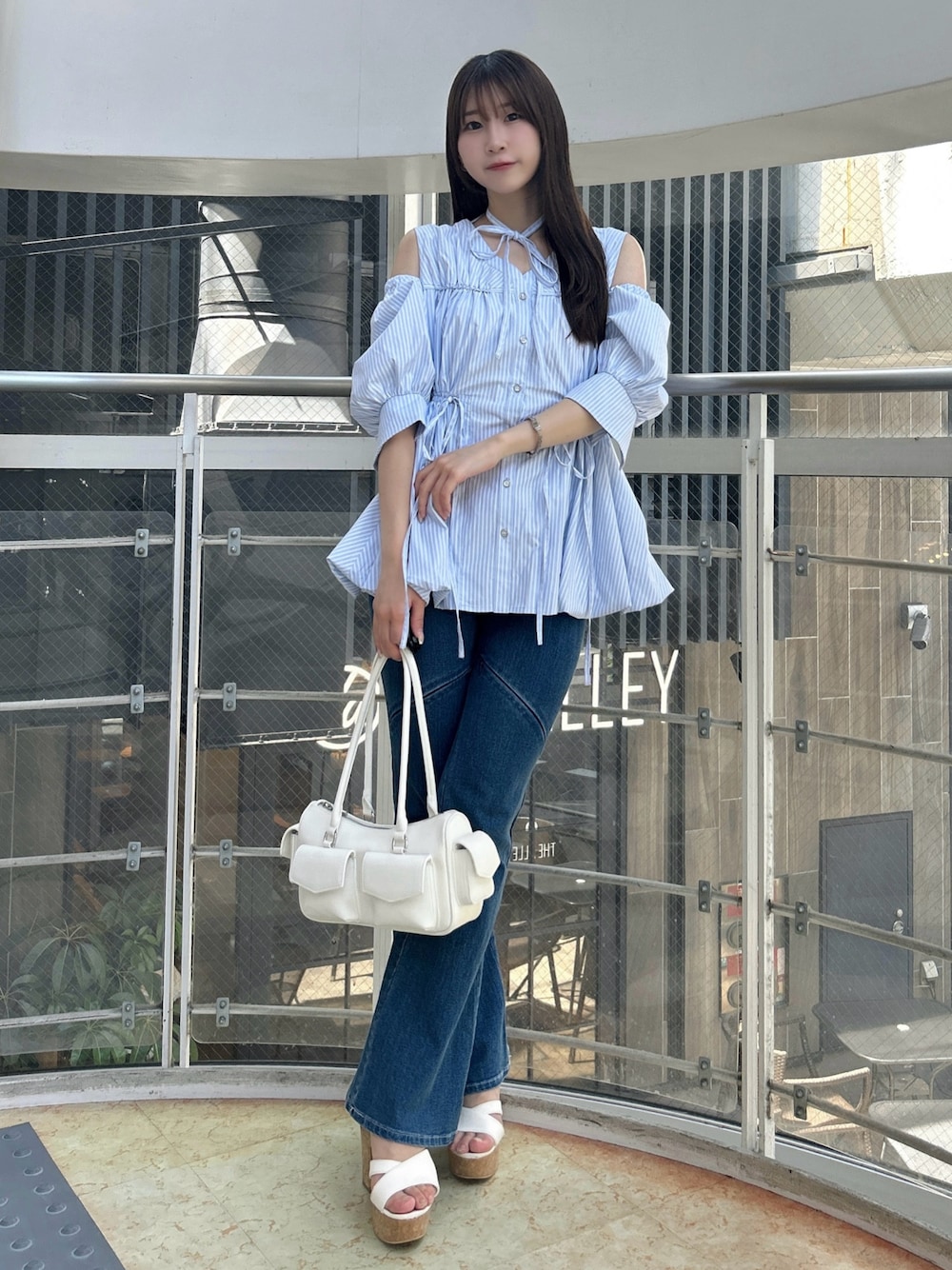 ブルー系のシャツ/ブラウス、ブルー系のデニムパンツ、ホワイト系のサンダルを着用したレディースの秋コーディネートの1枚目の写真