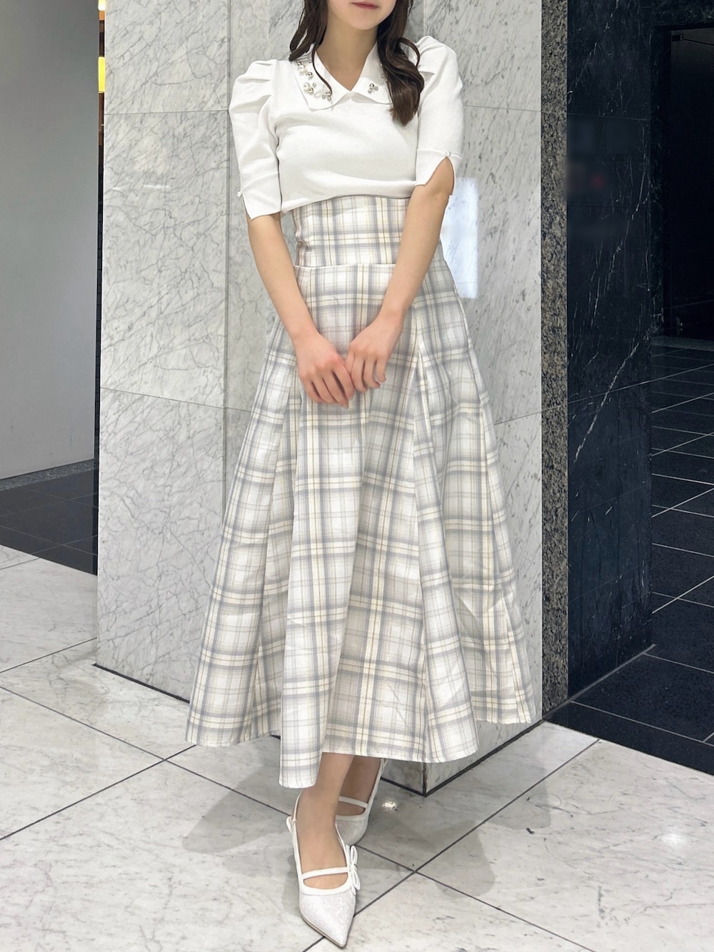 ホワイト系のニット/セーター、イエロー系のスカート、ホワイト系のパンプスを着用したレディースの春コーディネートの1枚目の写真