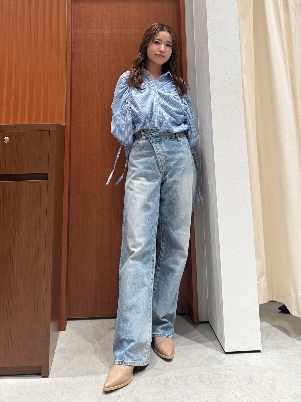 ブルー系のシャツ/ブラウス、ブルー系のデニムパンツ、ベージュ系のブーツを着用したレディースの春コーディネートの1枚目の写真