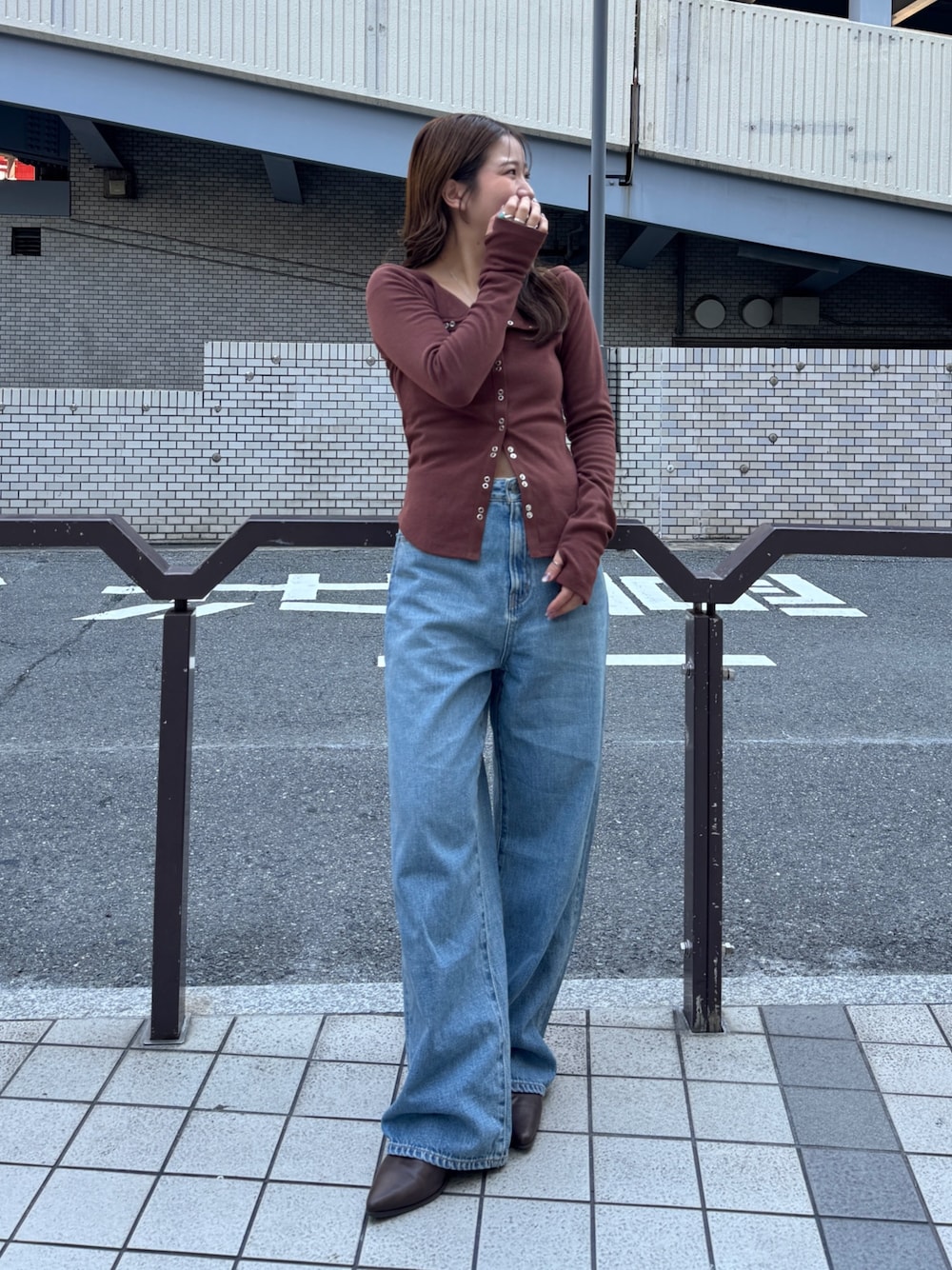 ブルー系のデニムパンツ、ブラウン系のTシャツ/カットソー、ブラウン系のブーツを着用したレディースの秋コーディネートの1枚目の写真