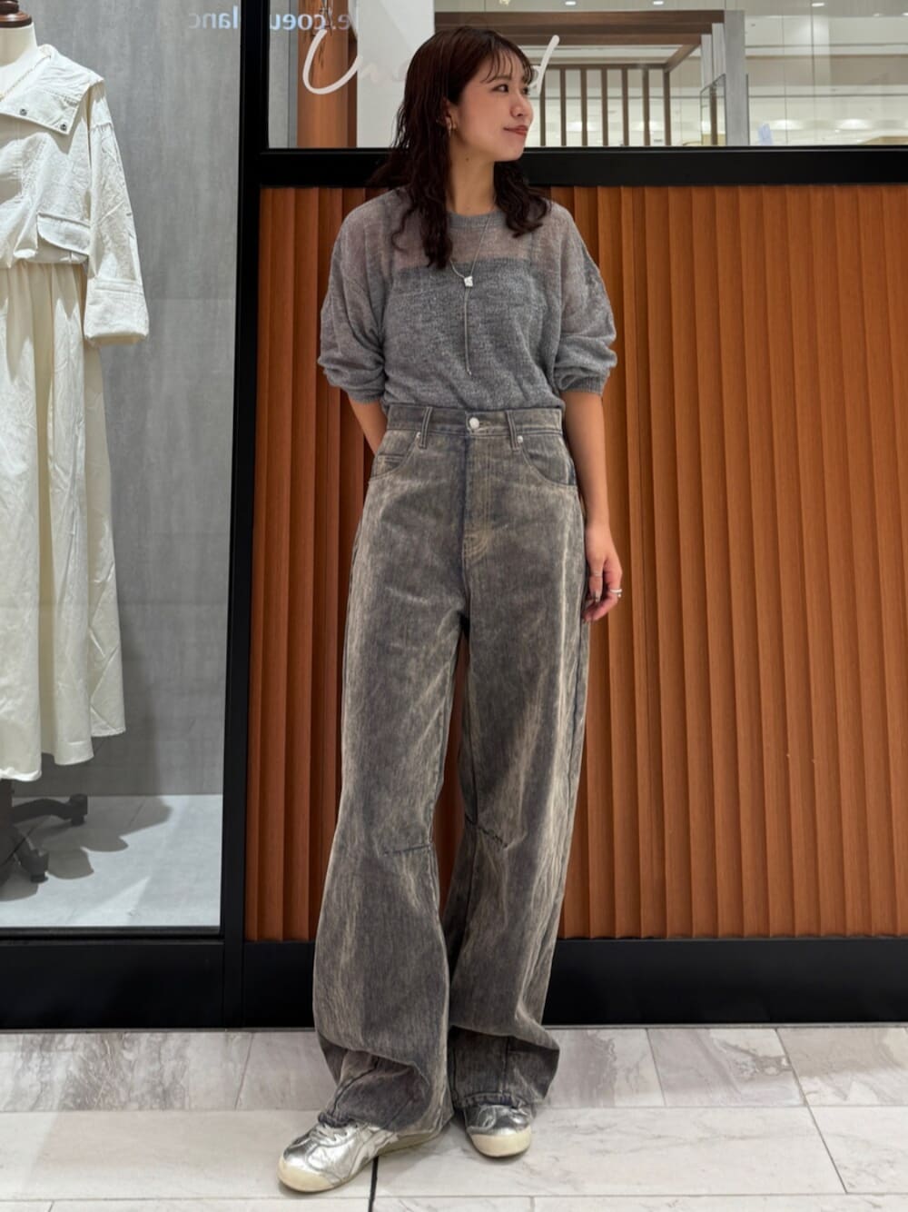 ベージュ系のデニムパンツ、グレー系のニット/セーターを着用したレディースの秋コーディネートの1枚目の写真