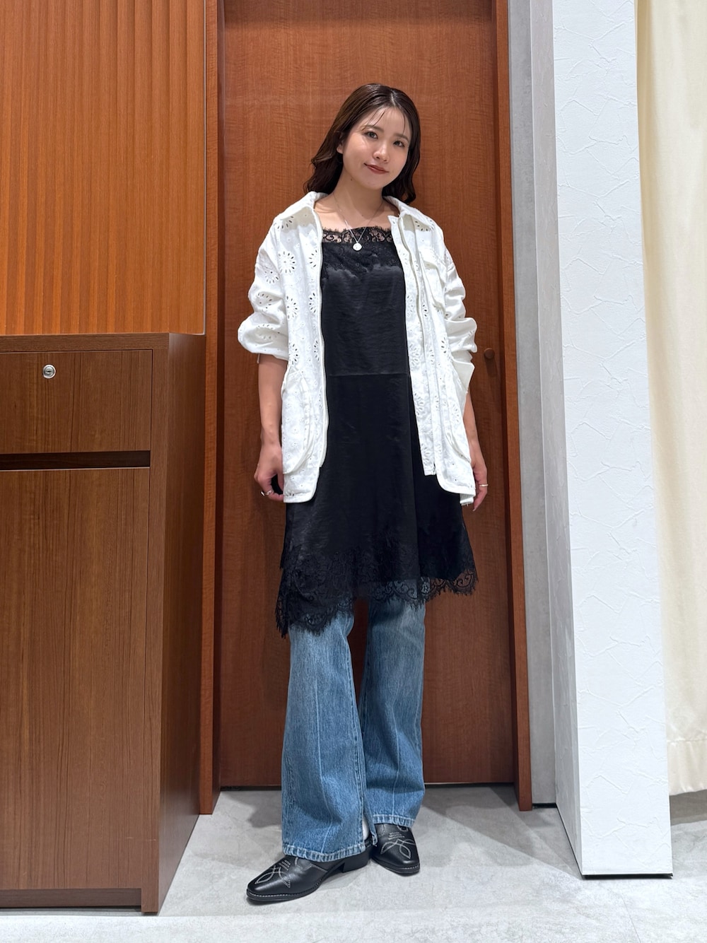 ホワイト系のブルゾン、ブラック系のワンピース、ブルー系のデニムパンツを着用したレディースの夏コーディネートの1枚目の写真