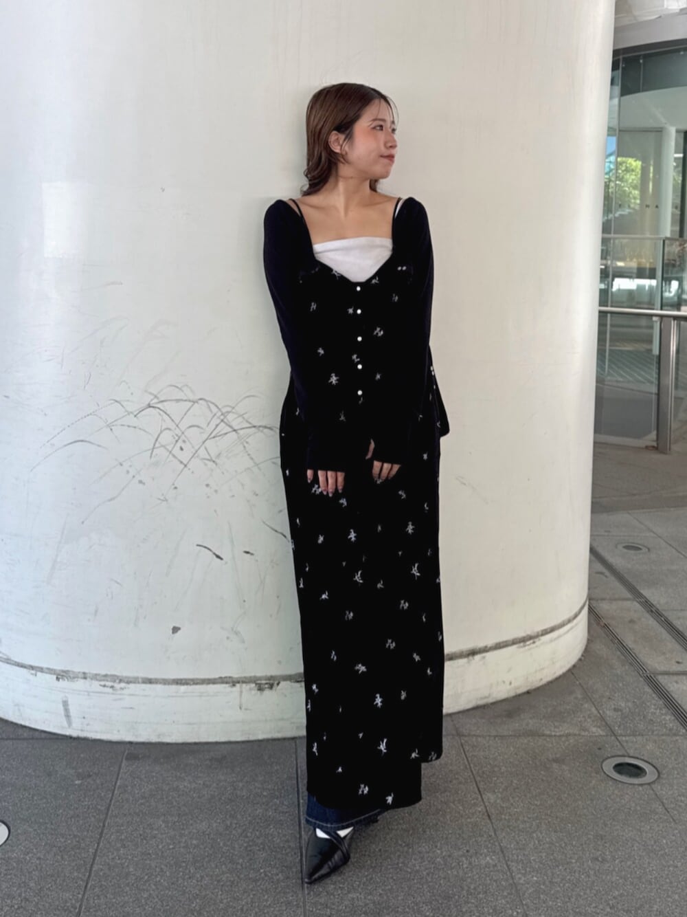 ブルー系のデニムパンツ、ブラック系のパンプス、ブラック系のワンピースを着用したレディースの秋コーディネートの1枚目の写真