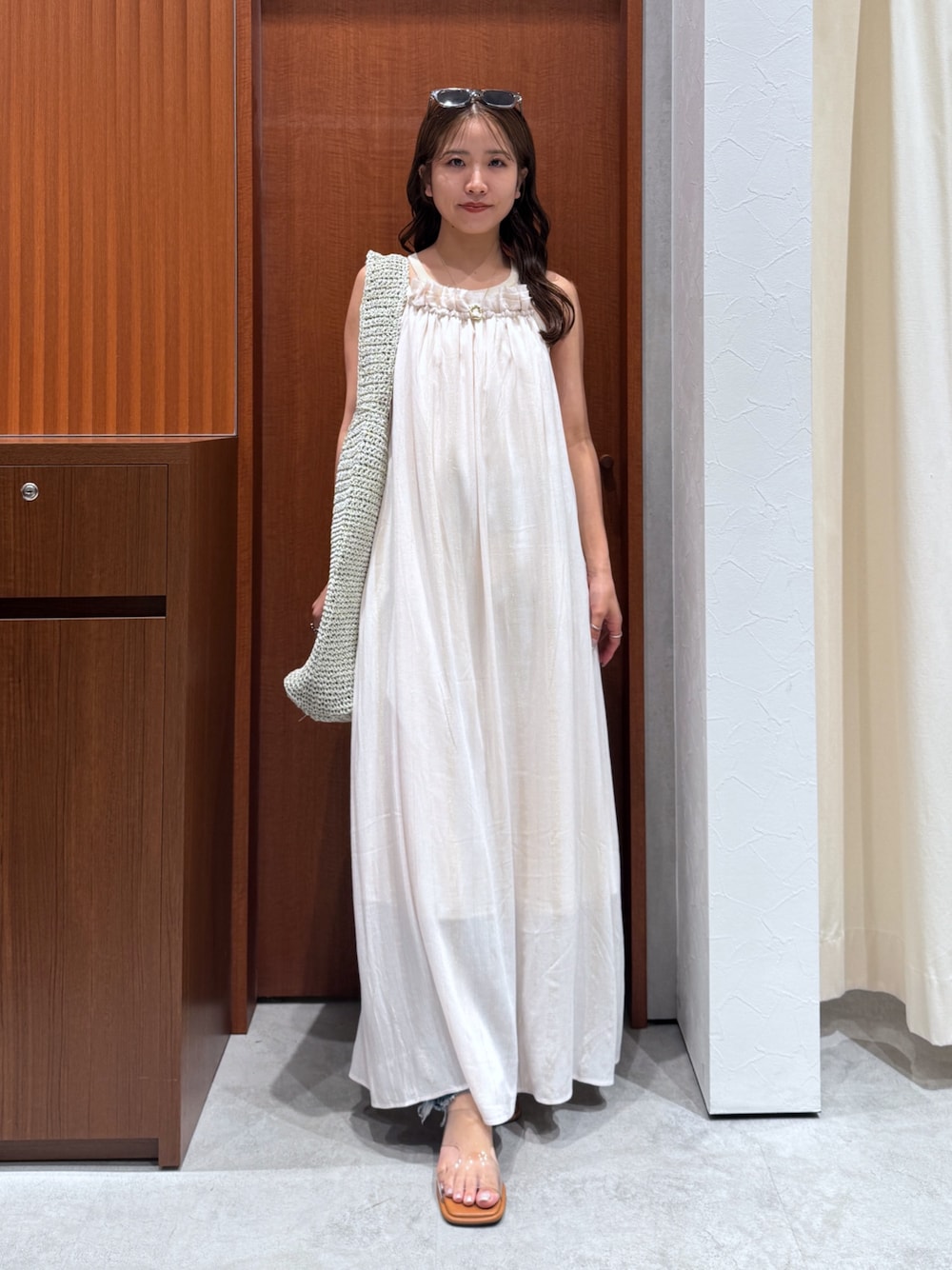 グレー系のショルダーバッグ、ホワイト系のワンピース、その他のサンダルを着用したレディースの夏コーディネートの1枚目の写真
