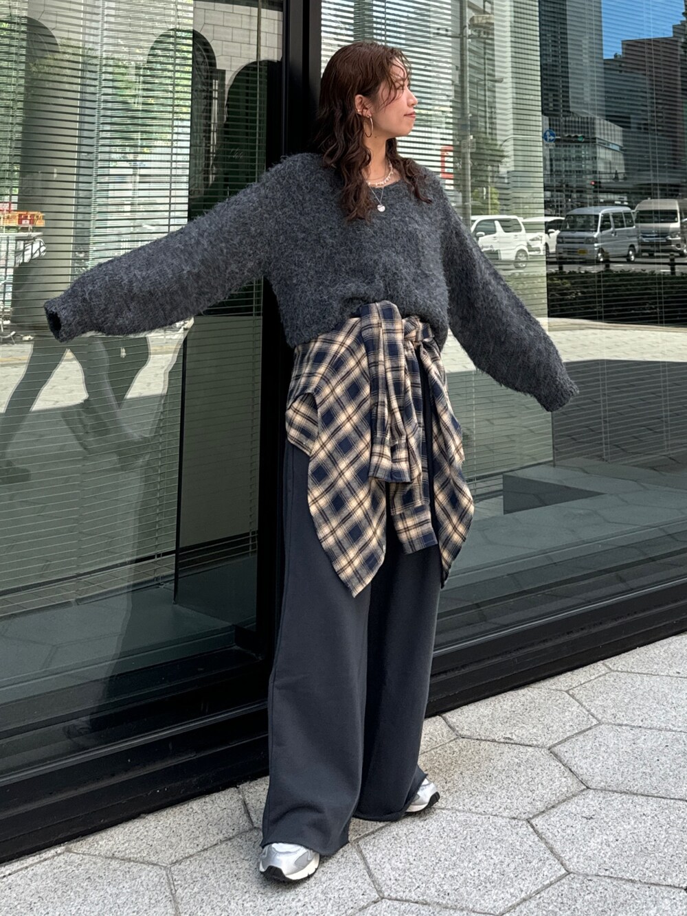 グレー系のスウェットパンツ、ブルー系のシャツ/ブラウス、グレー系のニット/セーターを着用したレディースの秋コーディネートの1枚目の写真