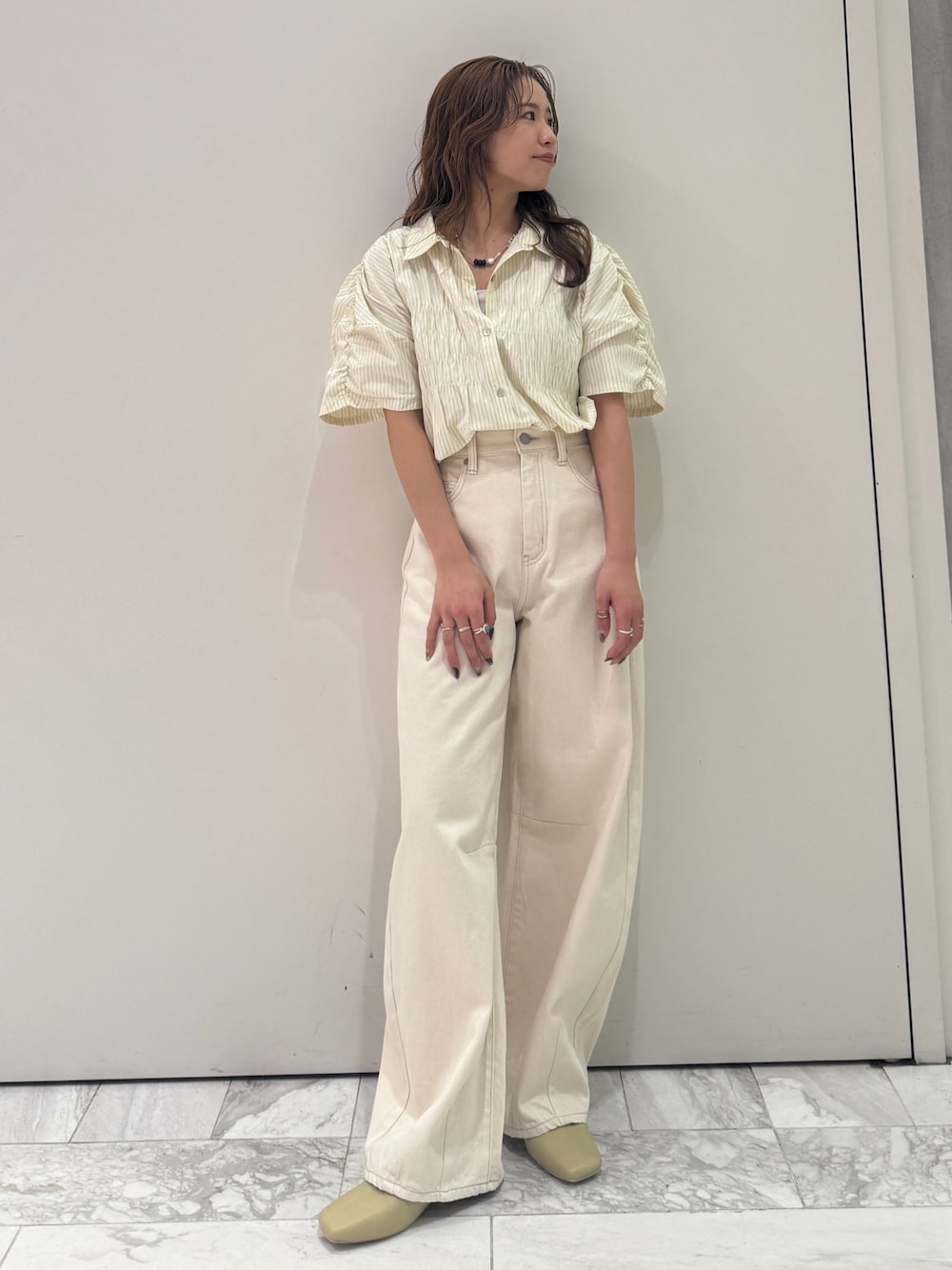 ホワイト系のデニムパンツ、イエロー系のシャツ/ブラウス、イエロー系のサンダルを着用したレディースの春コーディネートの1枚目の写真