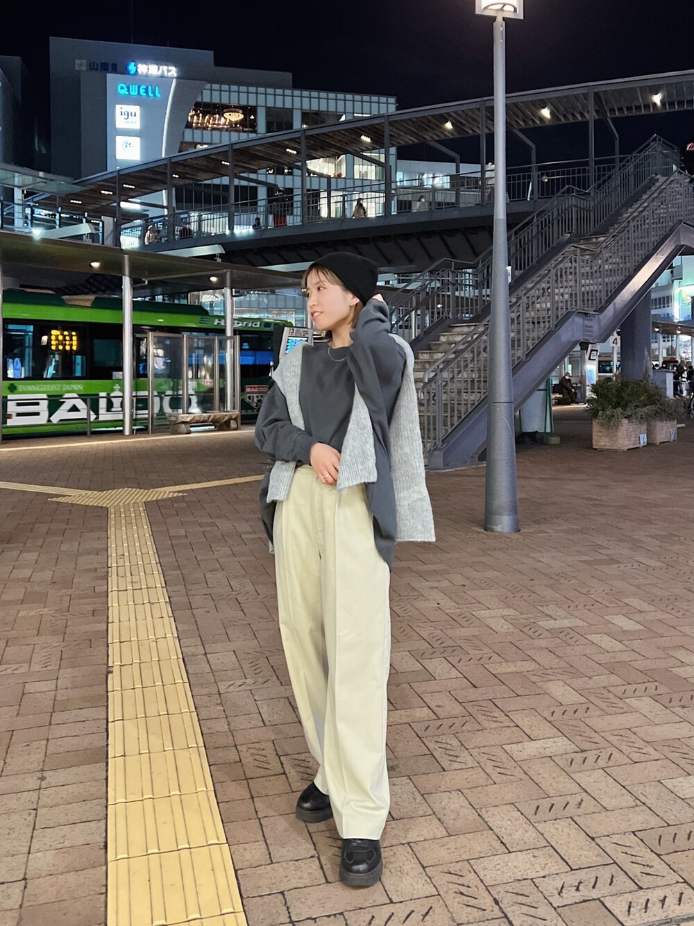 グレー系のTシャツ/カットソー、グレー系のニット/セーター、ベージュ系のスラックスを着用したレディースの冬コーディネートの1枚目の写真
