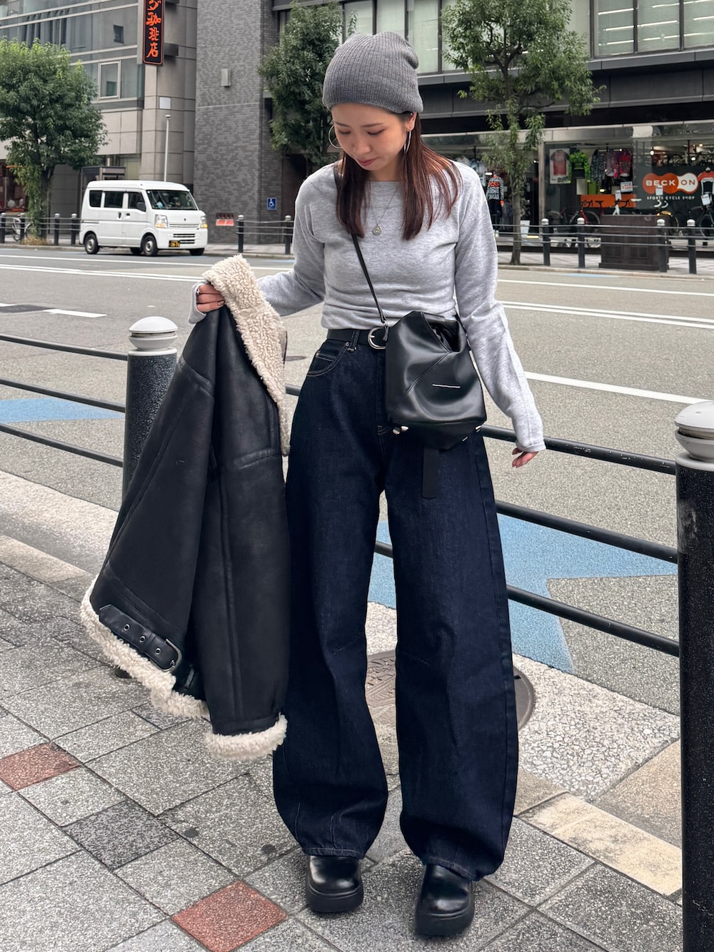 グレー系のニット/セーター、ブルー系のデニムパンツ、グレー系のニットキャップ/ビーニーを着用したレディースの秋コーディネートの1枚目の写真