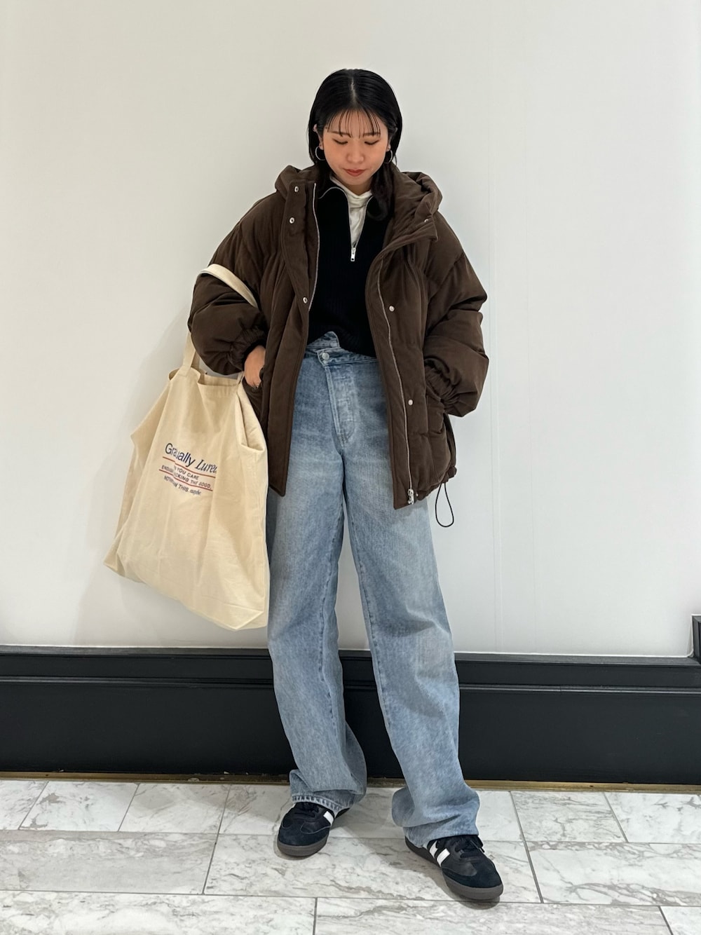 ブルー系のデニムパンツ、ホワイト系のトートバッグ、ホワイト系のTシャツ/カットソーを着用したレディースの冬コーディネートの1枚目の写真