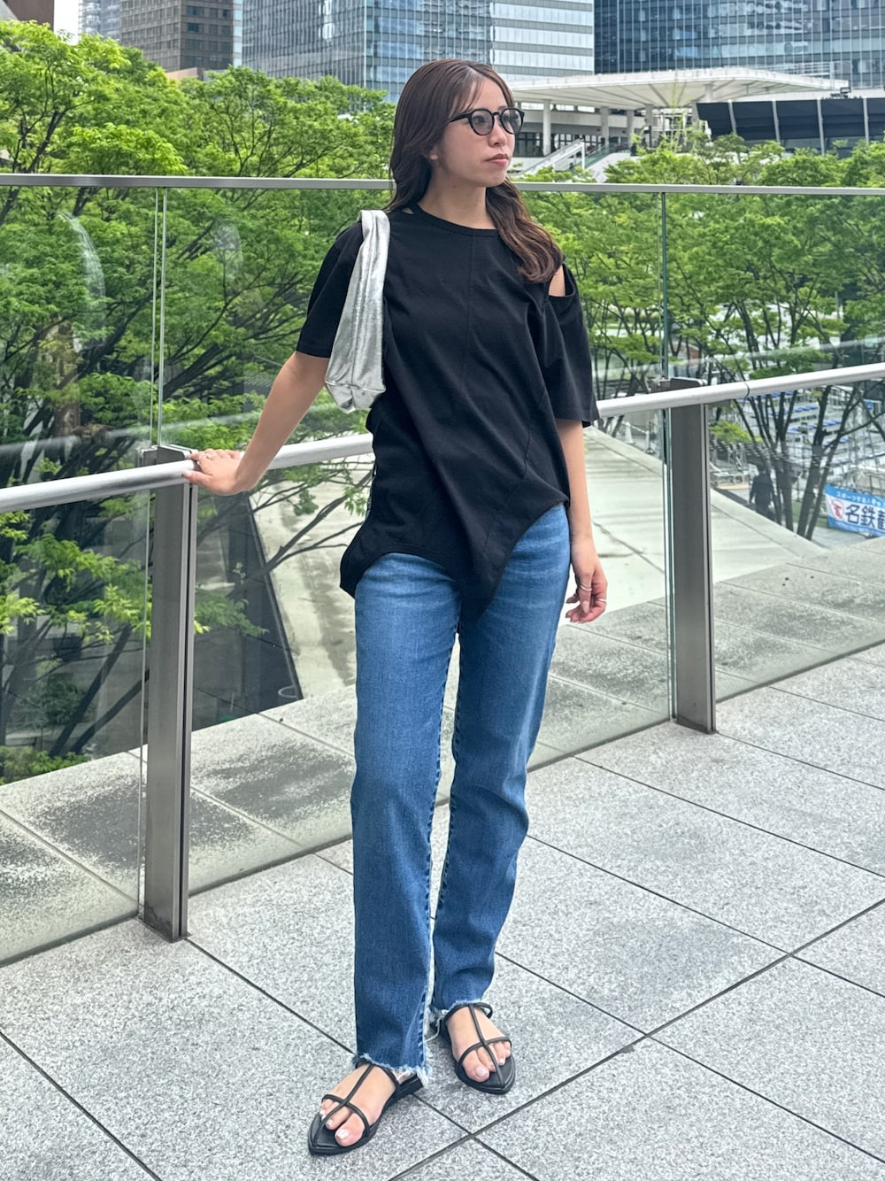ブラック系のTシャツ/カットソー、ブルー系のデニムパンツを着用したレディースの春コーディネートの1枚目の写真