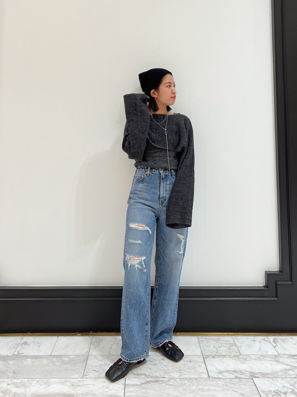 ブルー系のデニムパンツ、グレー系のニット/セーター、ブラック系のパンプスを着用したレディースの春コーディネートの1枚目の写真