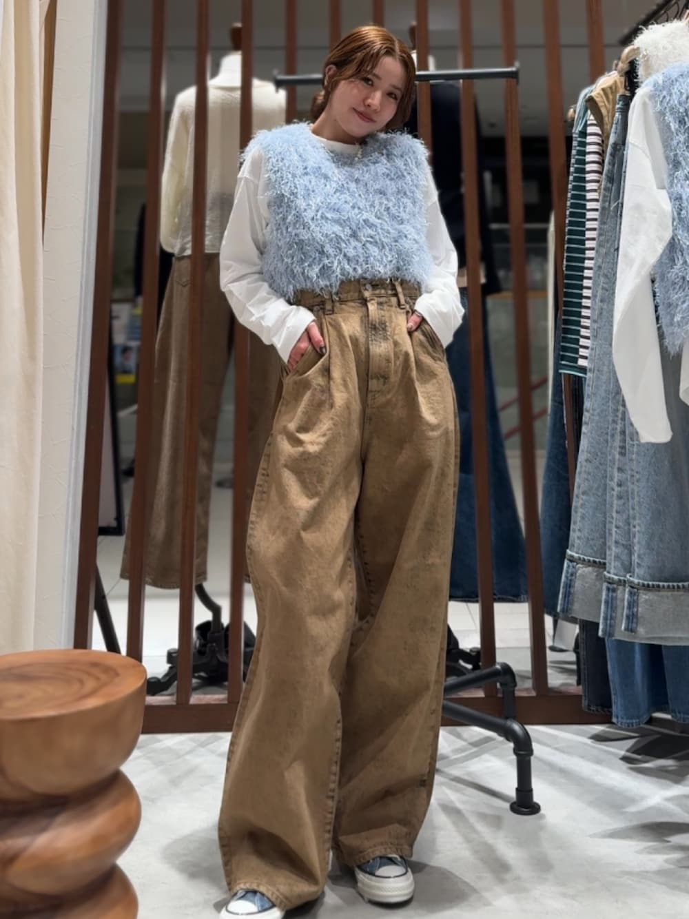 ブラウン系のデニムパンツ、ブルー系のニット/セーター、ホワイト系のTシャツ/カットソーを着用したレディースの春コーディネートの1枚目の写真