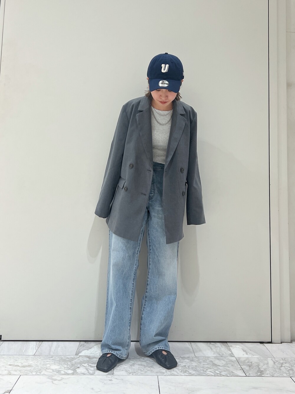グレー系のテーラードジャケット、ブルー系のデニムパンツ、ブラック系のパンプスを着用したレディースの冬コーディネートの1枚目の写真