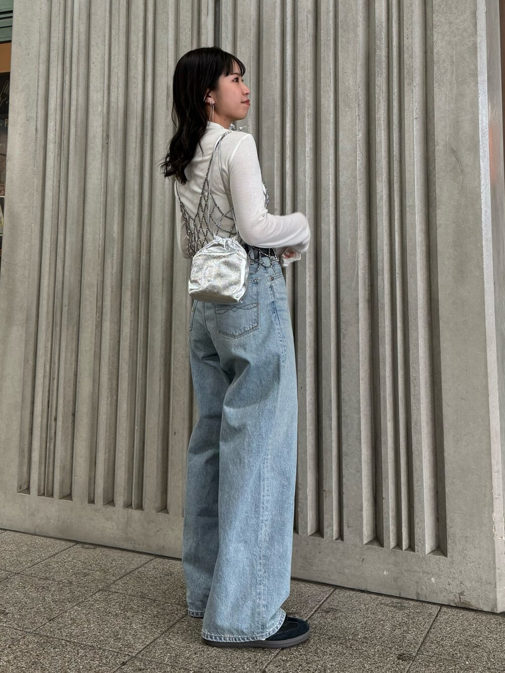 ブラック系のベスト、ブルー系のデニムパンツ、ホワイト系のTシャツ/カットソーを着用したレディースの冬コーディネートの1枚目の写真