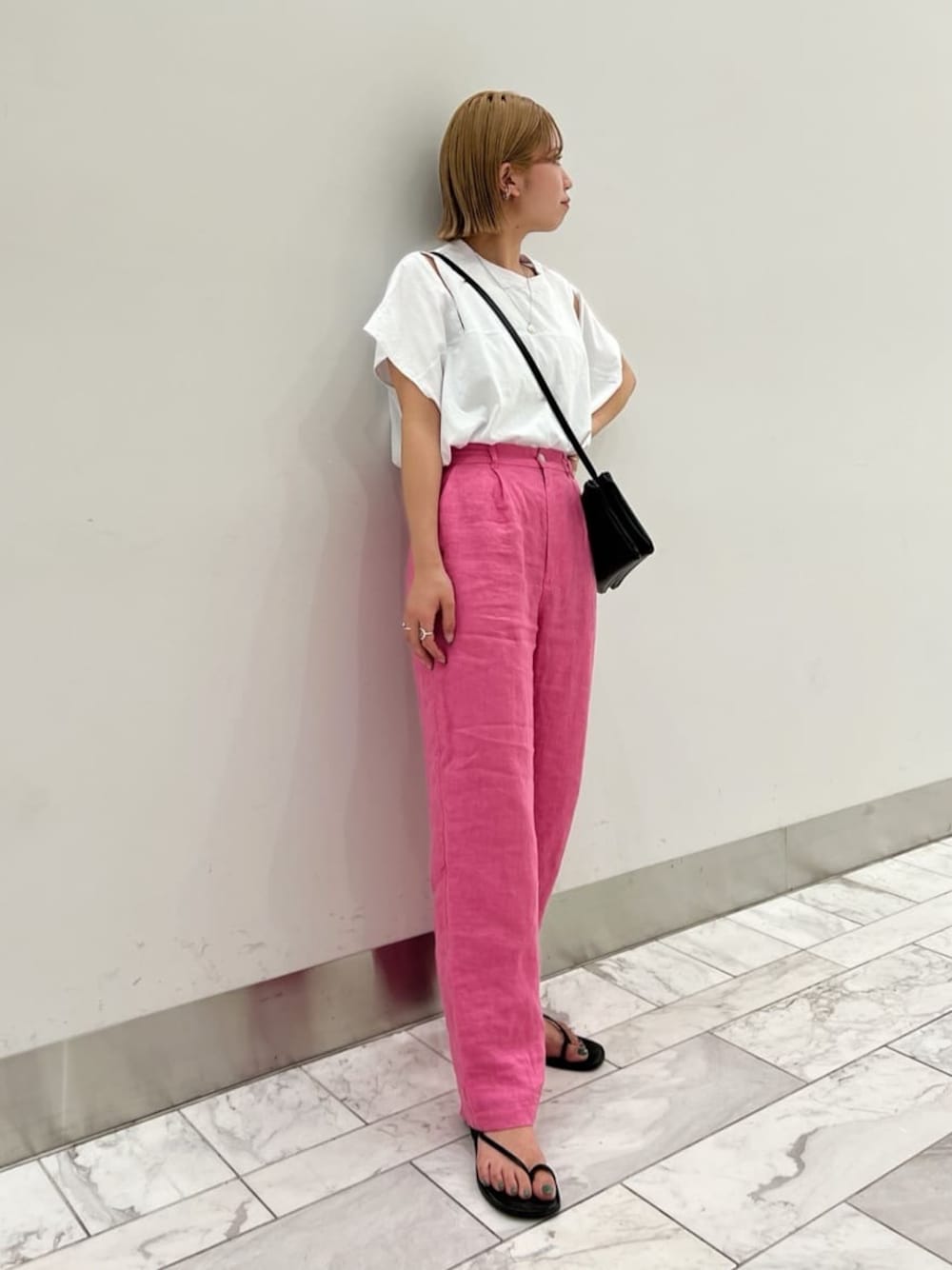 ブラック系のサンダル、ブラック系のショルダーバッグ、ホワイト系のTシャツ/カットソーを着用したレディースの春コーディネートの1枚目の写真