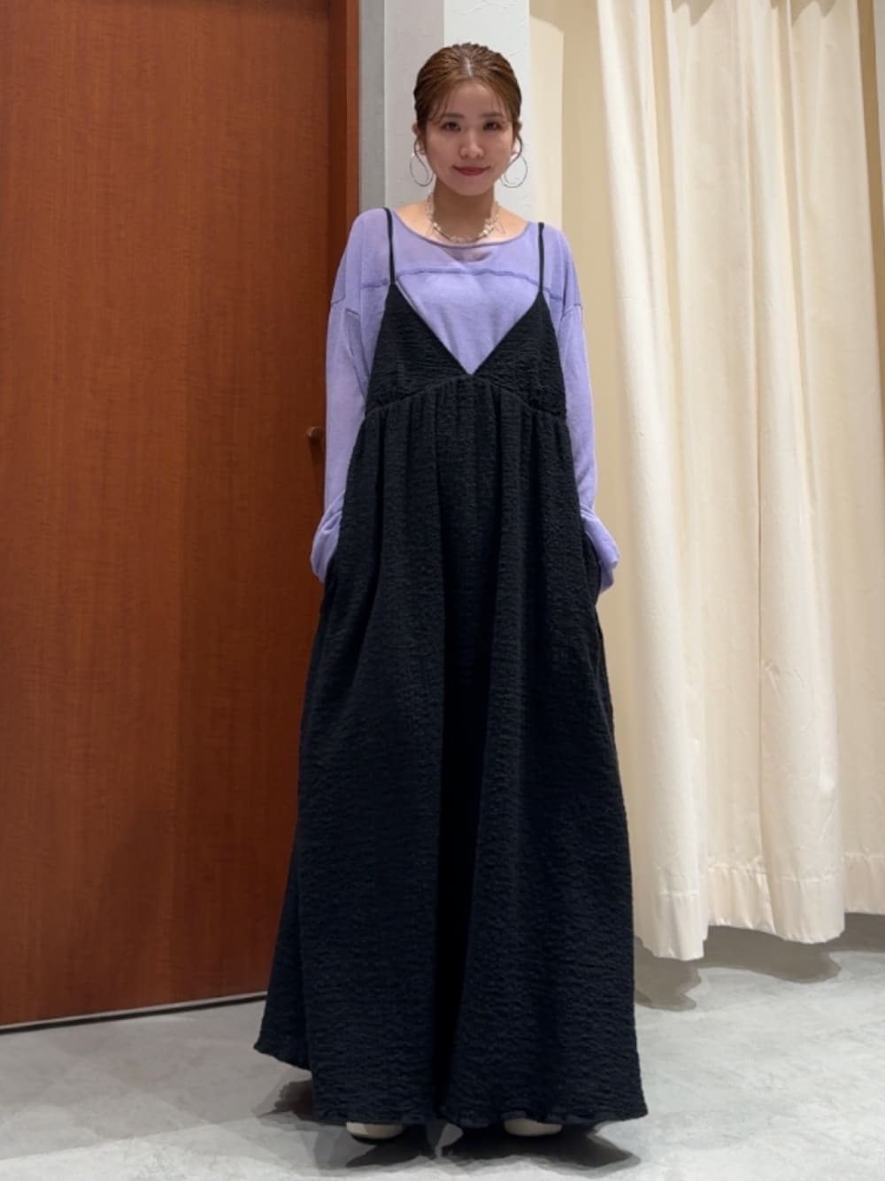 ブラック系のワンピース、パープル系のニット/セーター、ブルー系のデニムパンツを着用したレディースの春コーディネートの1枚目の写真