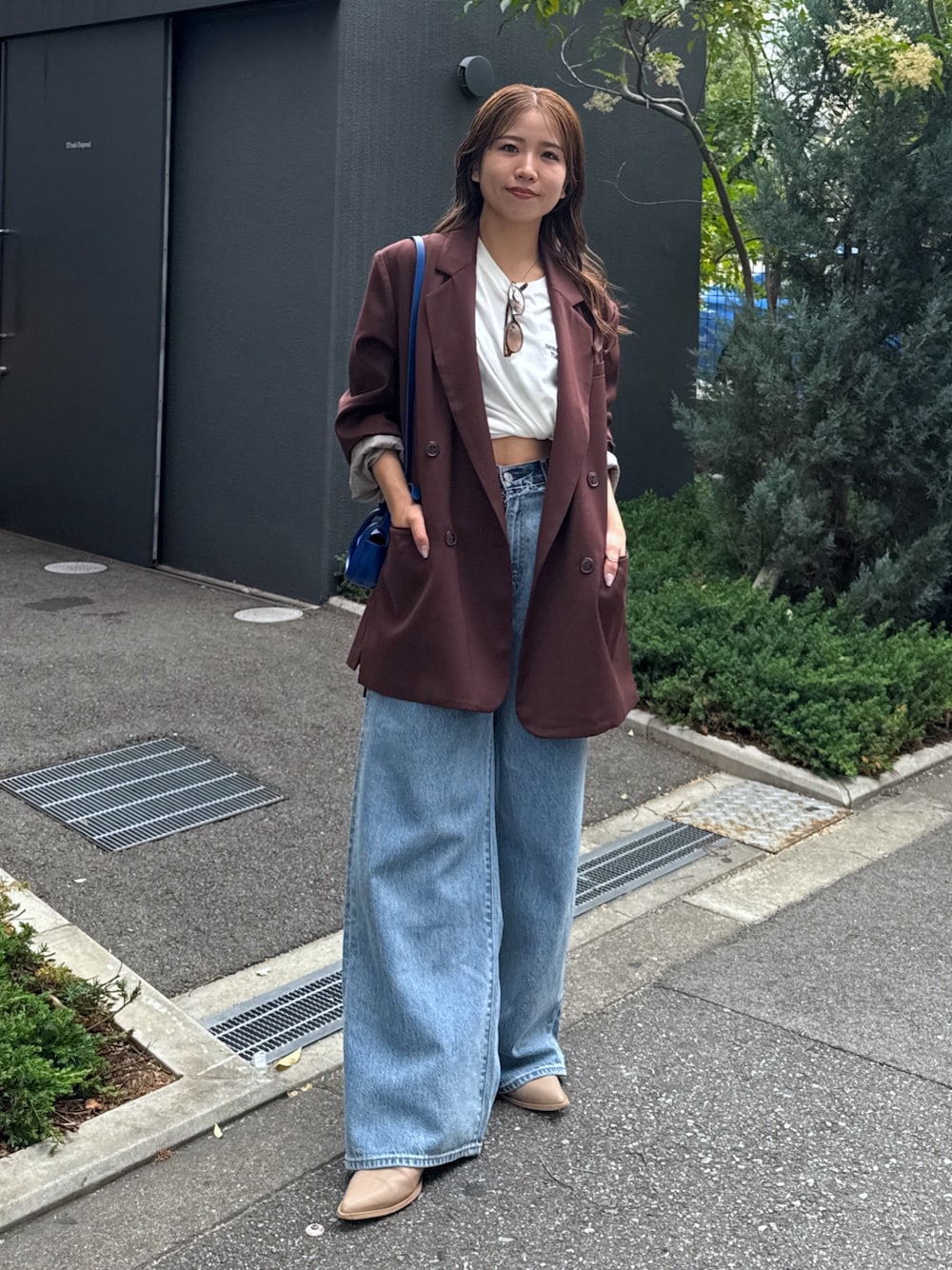 ブルー系のデニムパンツ、ブラウン系のテーラードジャケット、ホワイト系のTシャツ/カットソーを着用したレディースの夏コーディネートの1枚目の写真