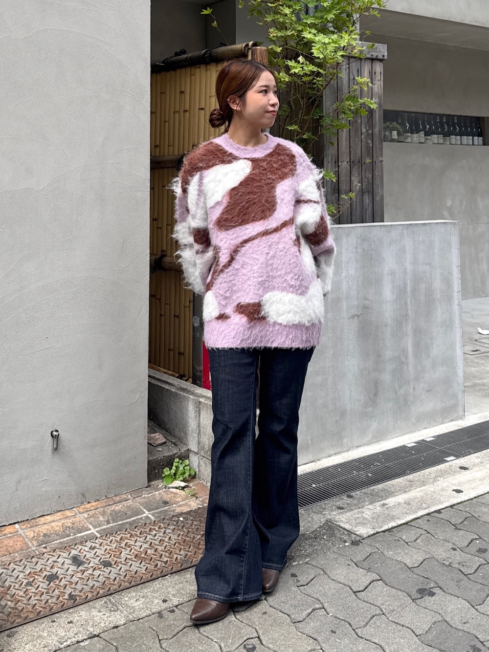 ブルー系のデニムパンツ、ブラウン系のブーツ、ピンク系のニット/セーターを着用したレディースの秋コーディネートの1枚目の写真