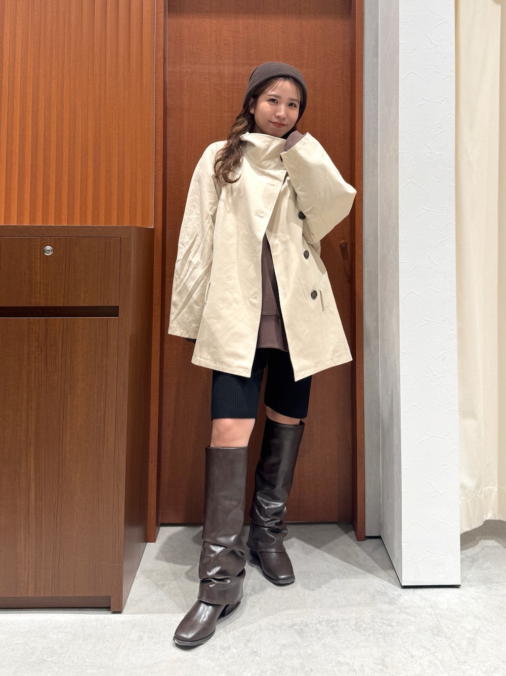 ベージュ系のトレンチコート、ブラウン系のスウェット、ブラック系のその他パンツを着用したレディースの秋コーディネートの1枚目の写真