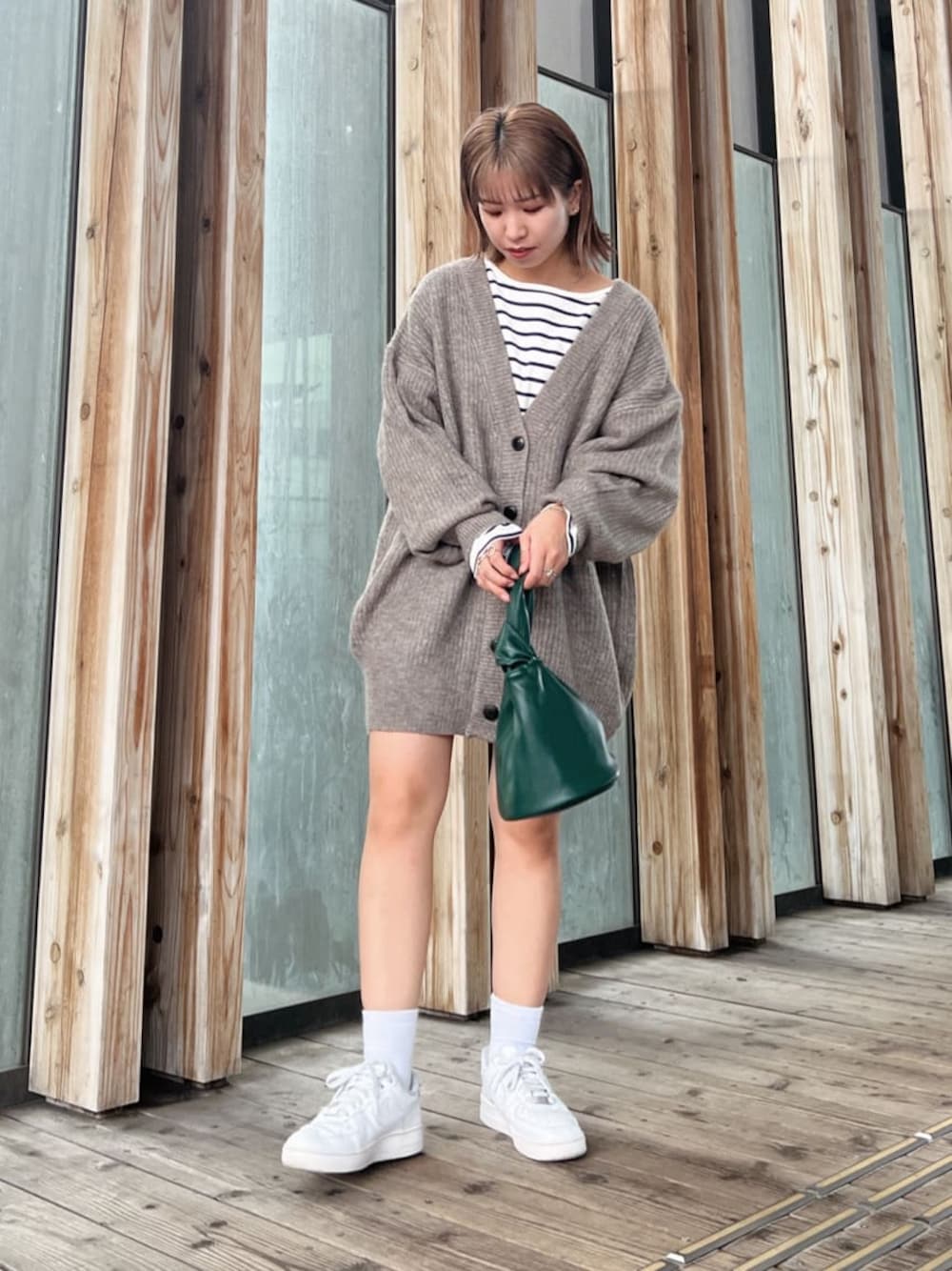 ベージュ系のステンカラーコート、ベージュ系のステンカラーコート、ブルー系のTシャツ/カットソーを着用したレディースの秋コーディネートの1枚目の写真