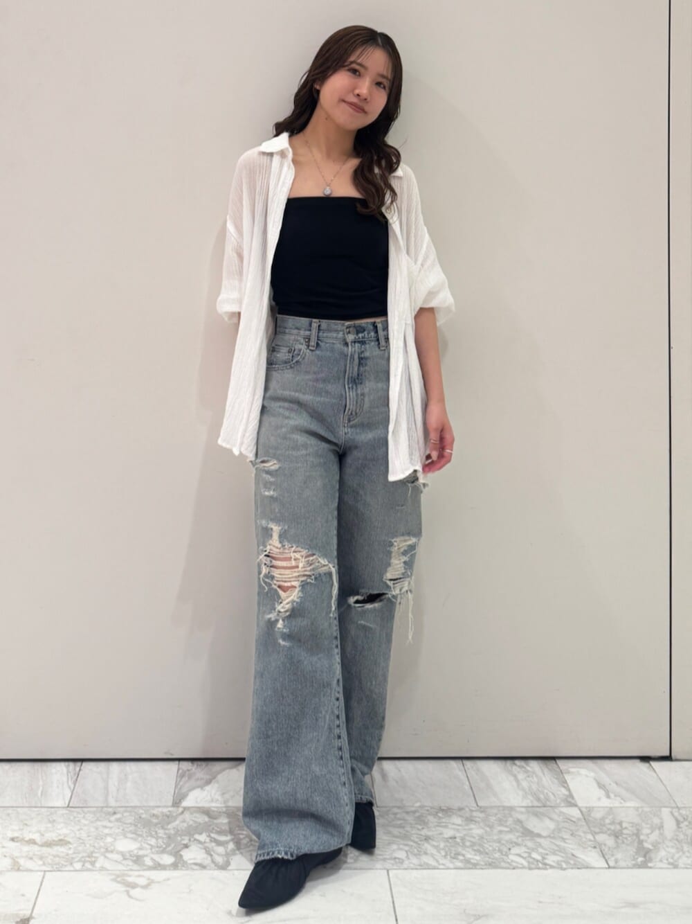 ブラック系のパンプス、ホワイト系のシャツ/ブラウス、ブルー系のデニムパンツを着用したレディースの春コーディネートの1枚目の写真