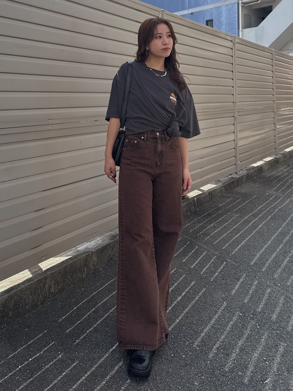 ブラウン系のデニムパンツ、グレー系のTシャツ/カットソーを着用したレディースの春コーディネートの1枚目の写真
