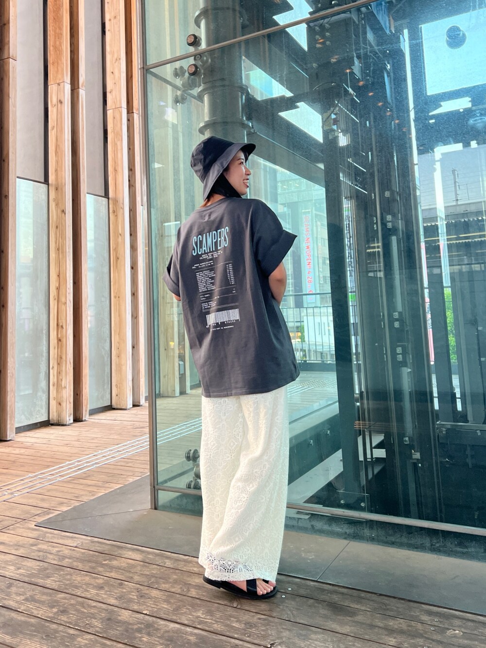 グレー系のTシャツ/カットソー、ホワイト系のその他パンツ、ブラック系のサンダルを着用したレディースの春コーディネートの1枚目の写真