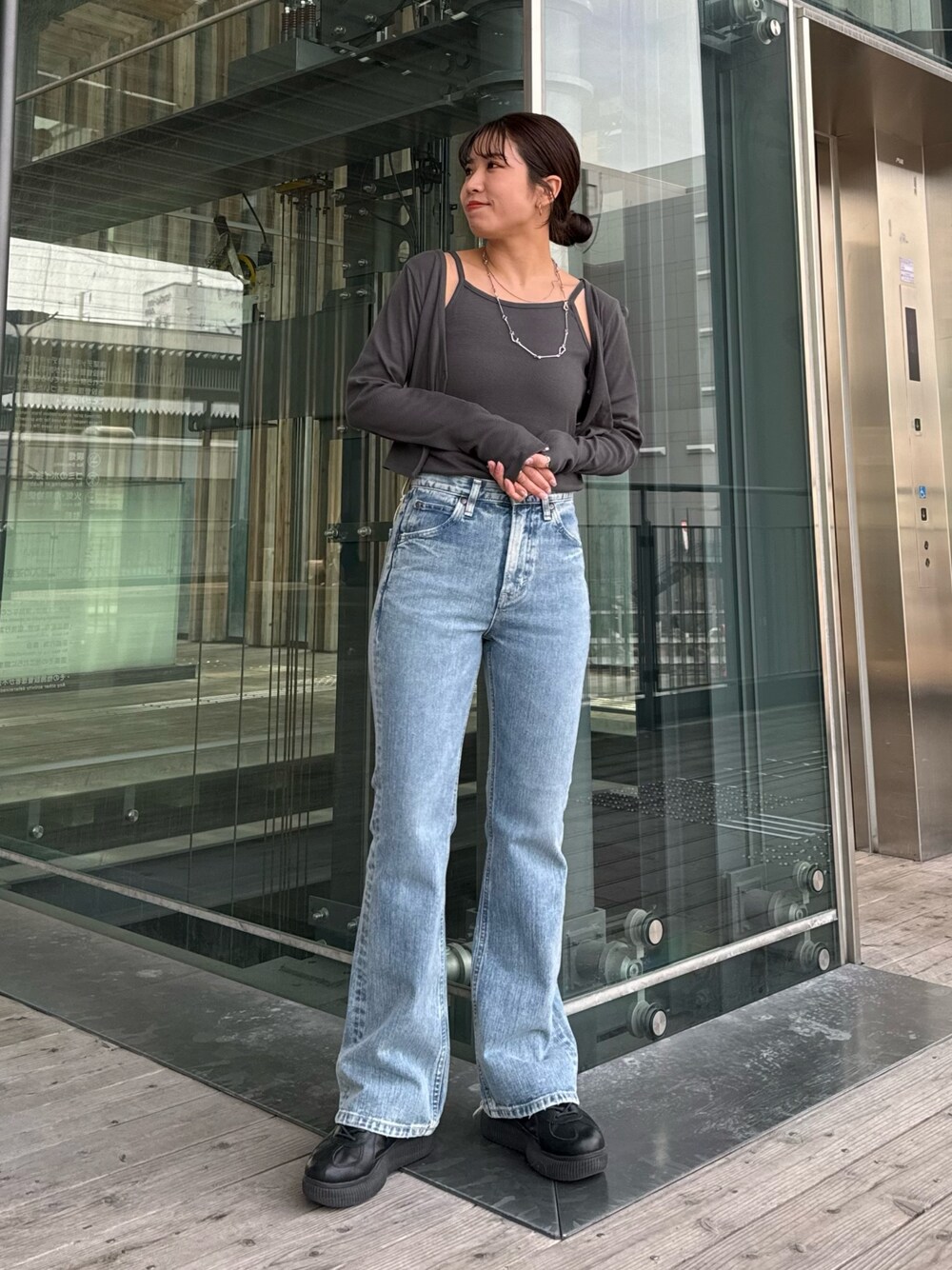 ブルー系のデニムパンツ、グレー系のTシャツ/カットソーを着用したレディースの春コーディネートの1枚目の写真