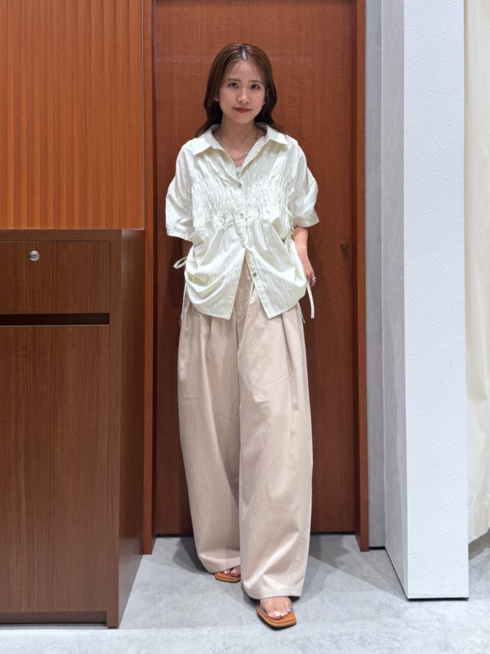 イエロー系のシャツ/ブラウス、その他のサンダル、ベージュ系のその他パンツを着用したレディースの夏コーディネートの1枚目の写真