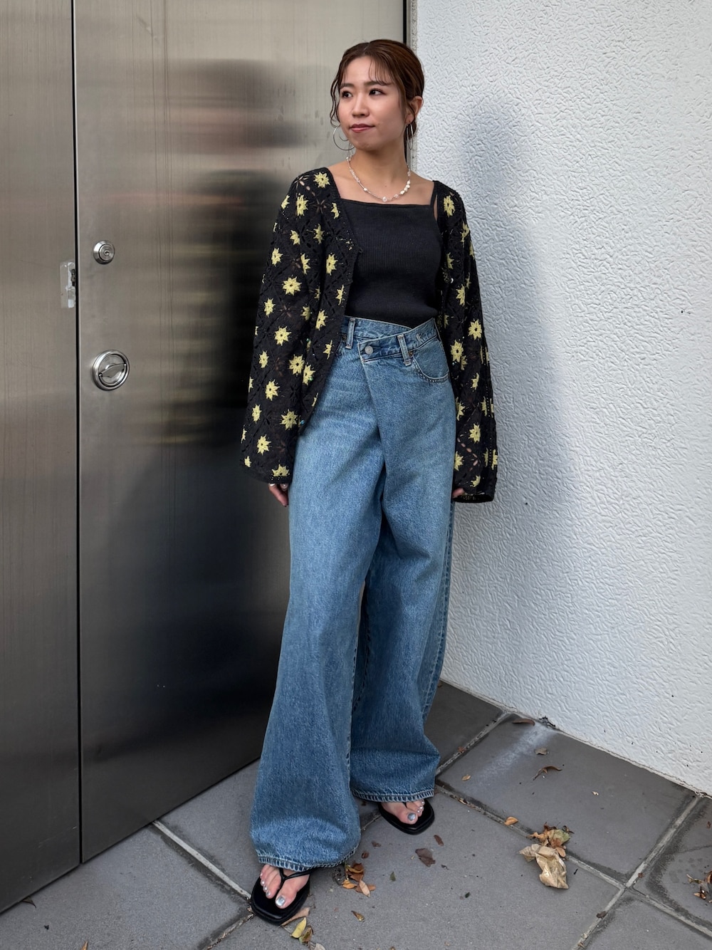 グレー系のカーディガン/ボレロ、ブルー系のデニムパンツ、ブラック系のサンダルを着用したレディースの春コーディネートの1枚目の写真