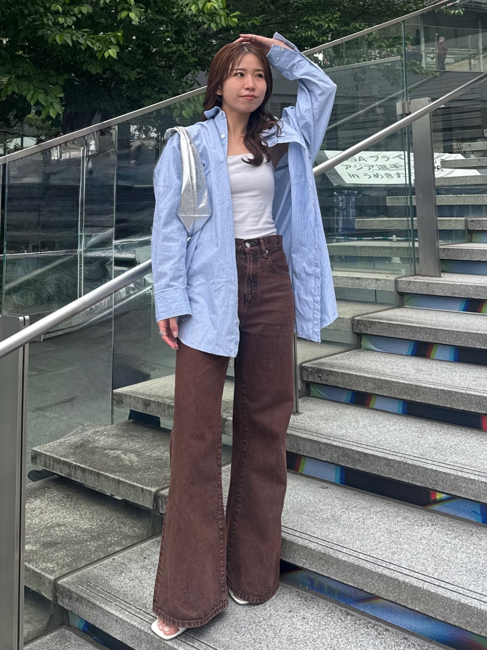 ブラウン系のデニムパンツ、ブルー系のシャツ/ブラウスを着用したレディースの春コーディネートの1枚目の写真