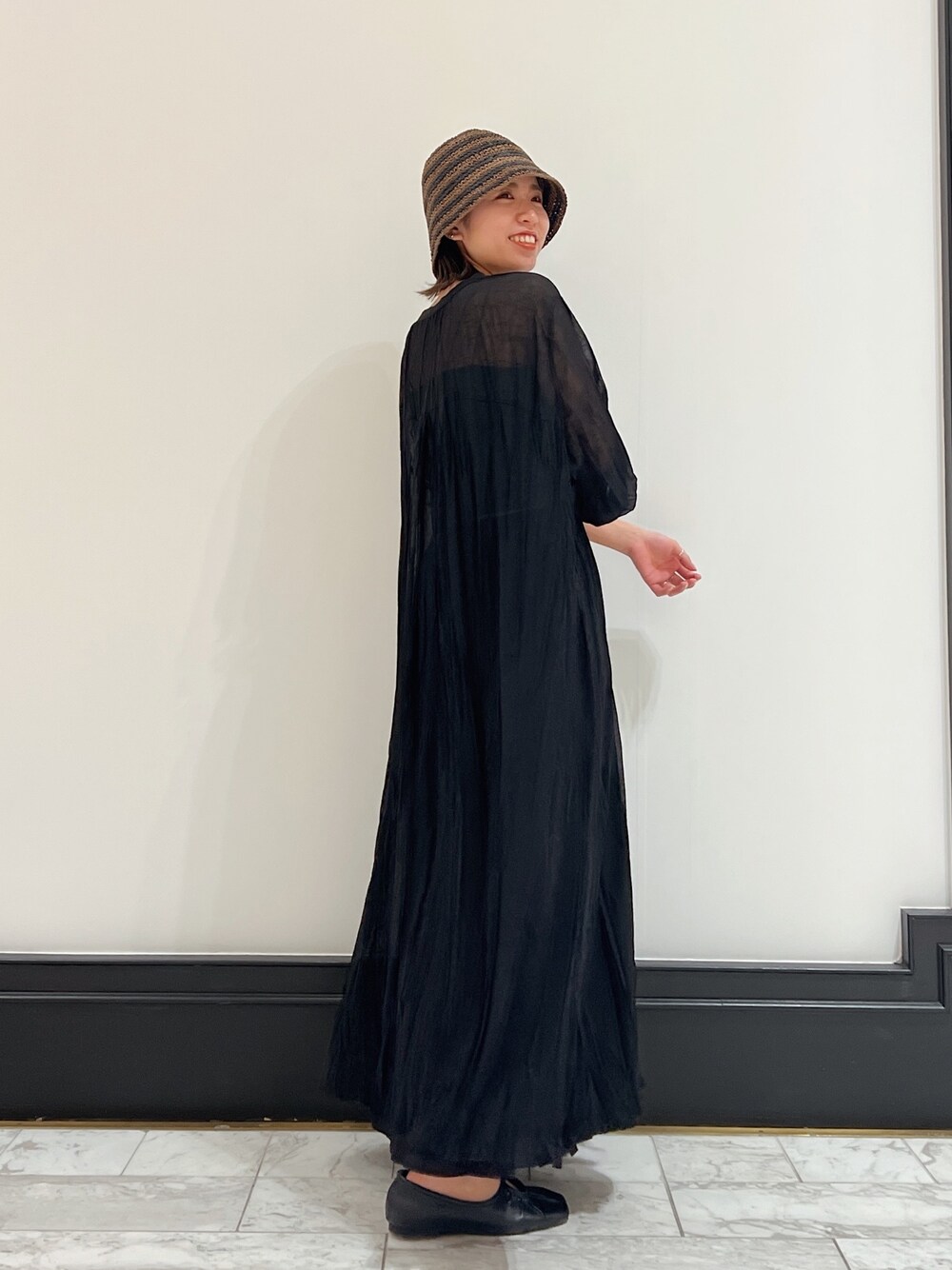 ブラック系のワンピース、ブラック系のパンプス、ブラック系のスカートを着用したレディースの春コーディネートの1枚目の写真