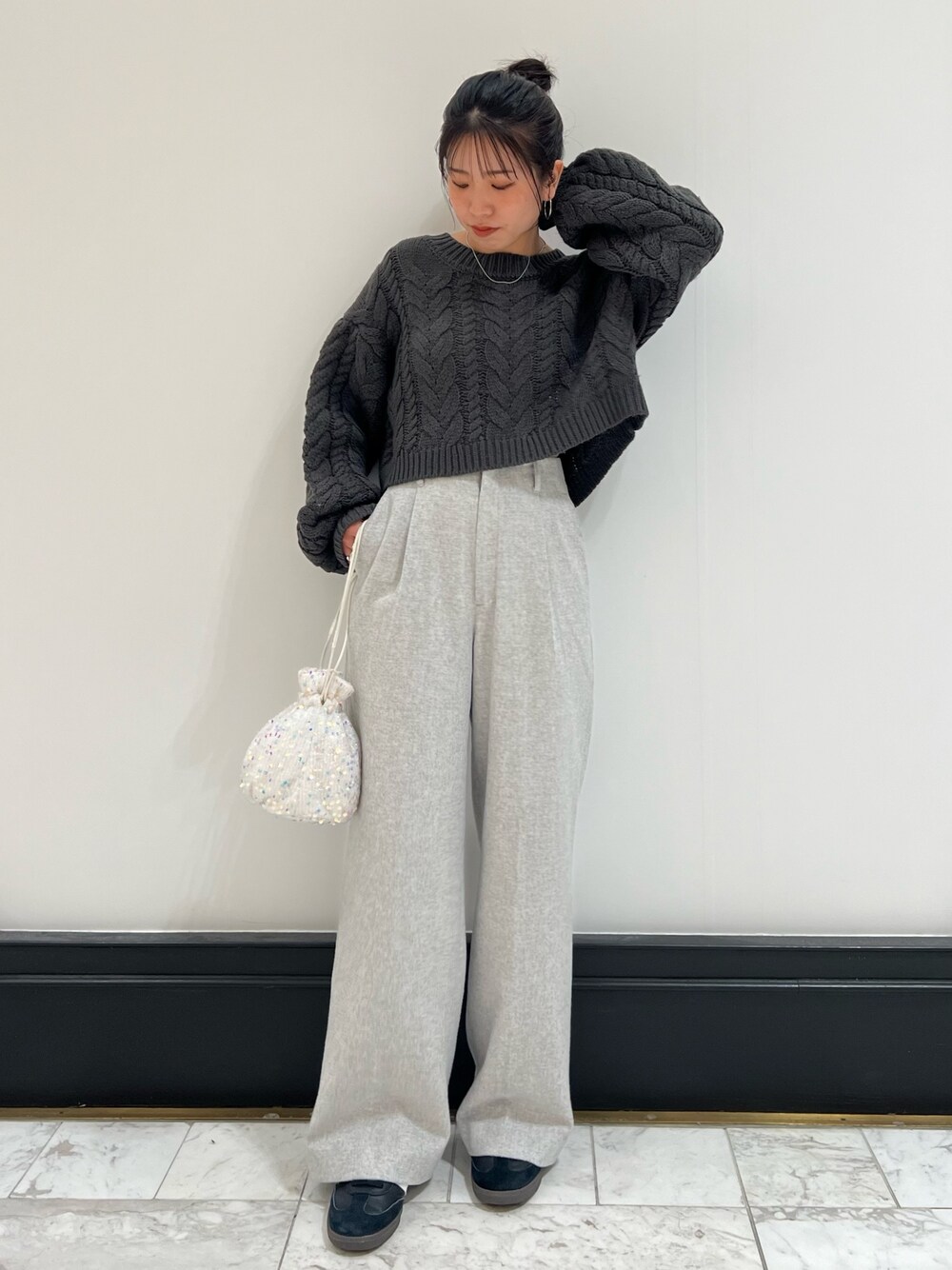 グレー系のその他パンツ、グレー系のニット/セーター、ホワイト系のハンドバッグを着用したレディースの冬コーディネートの1枚目の写真
